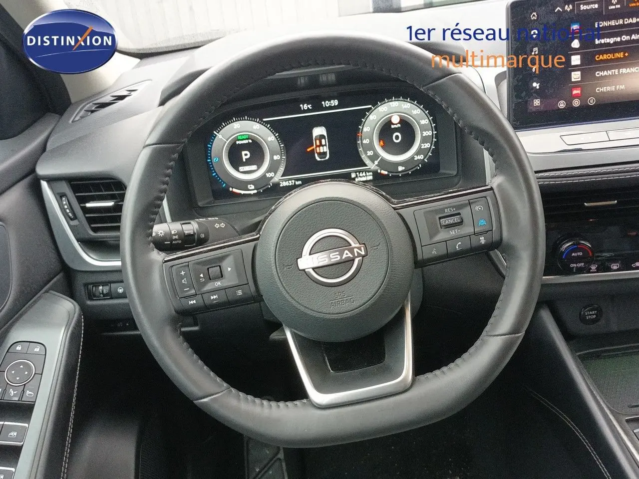 Vue rapprochée du volant cuir noir du Nissan Qashqai e-POWER 2025 avec tableau de bord numérique et écran central tactile.