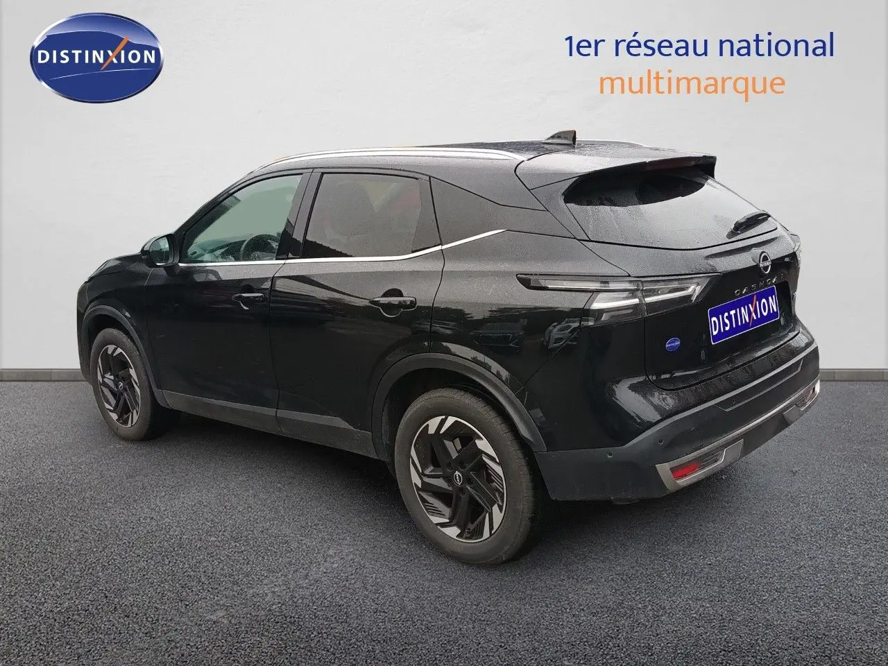Vue 3/4 arrière côté gauche du Nissan Qashqai e-POWER 2025 noir Kuro Metal avec jantes stylisées et feux arrière LED fins.