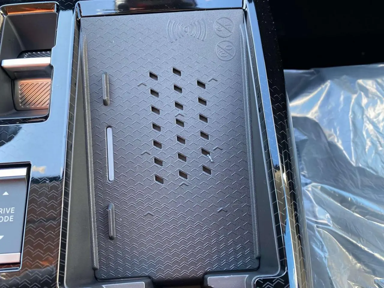 Détail du chargeur sans fil noir au centre de la console du Citroën C5 Aircross 2026, intérieur moderne.