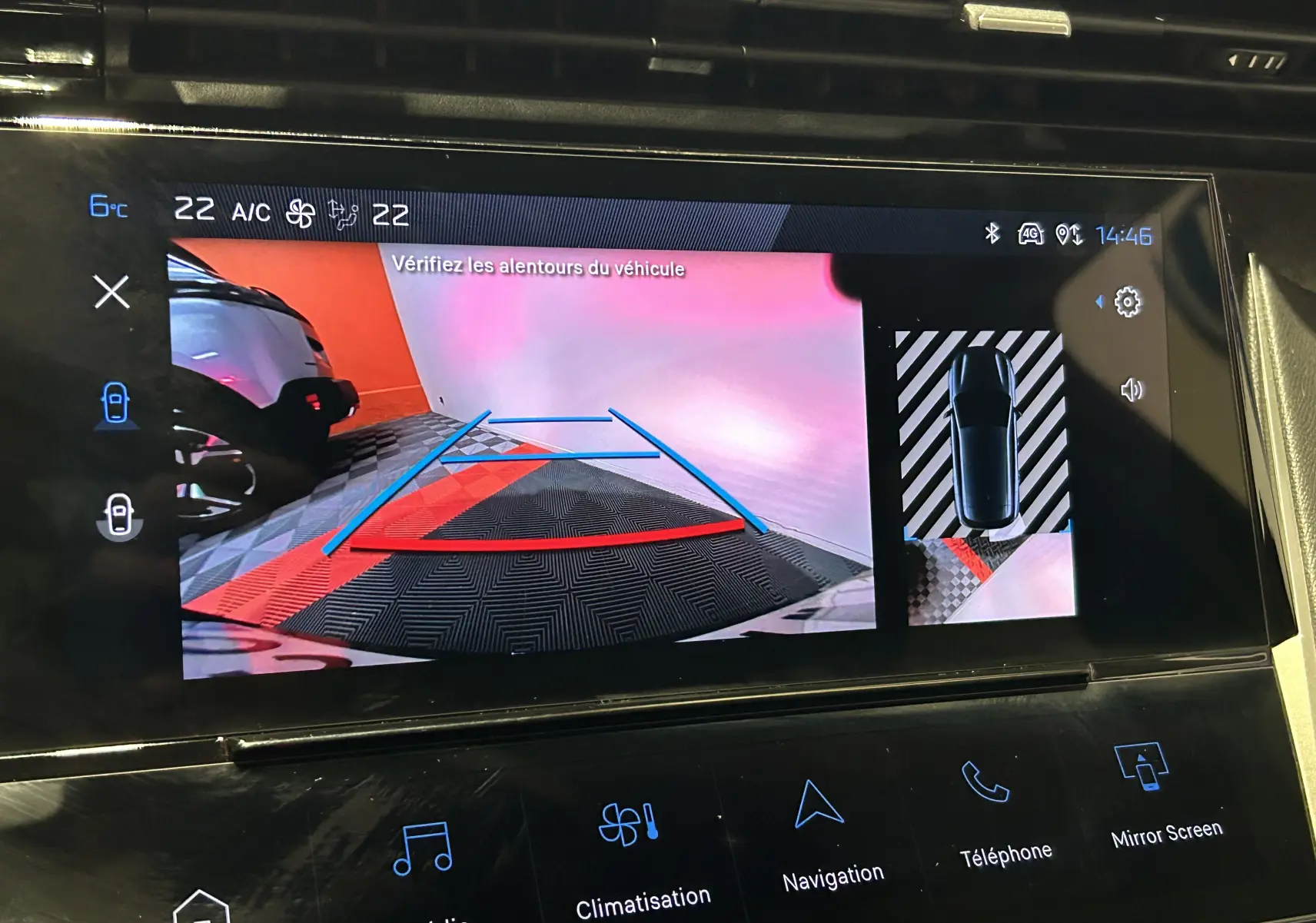 Écran de caméra de recul de la Peugeot 308 rouge, affichant les lignes de guidage et vue 360° du véhicule.