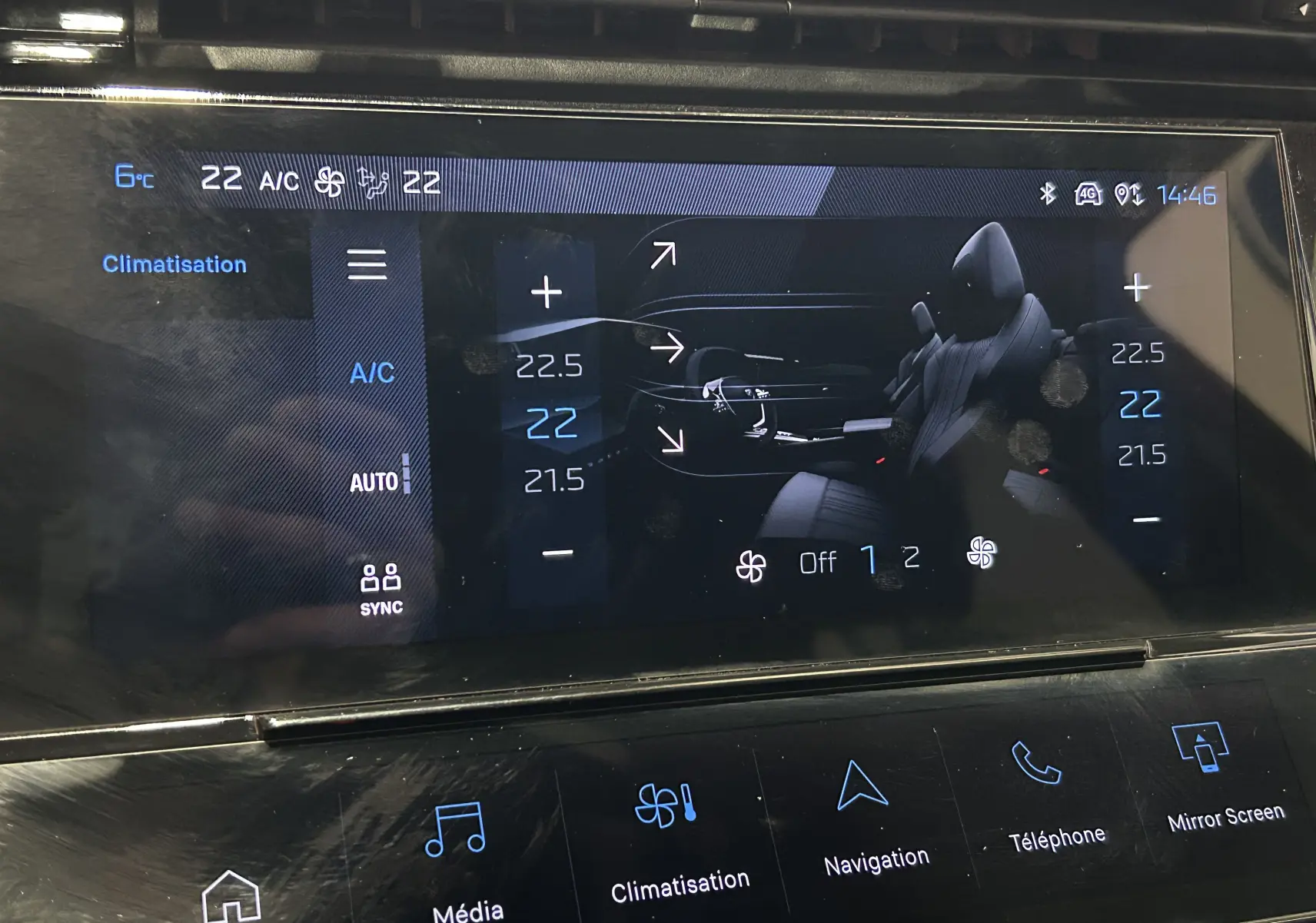 Écran tactile central de la Peugeot 308 rouge 2024 montrant les réglages de climatisation et la vue intérieure du véhicule.