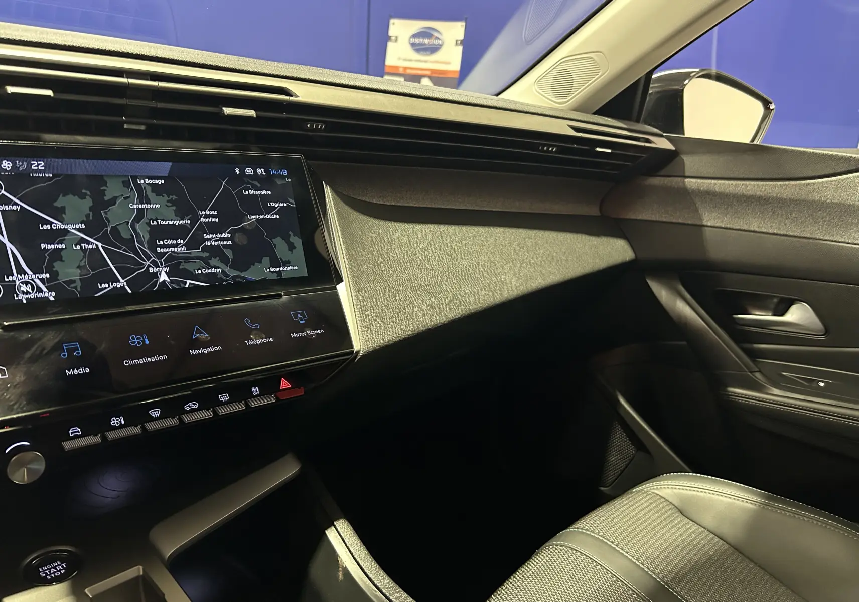 Vue intérieure côté passager de la Peugeot 308 2024 avec écran tactile GPS et finition noire moderne.