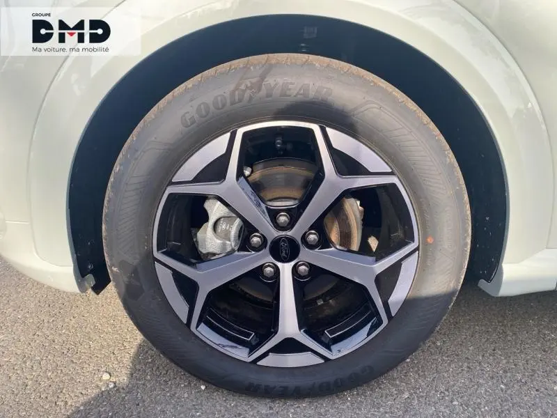 Gros plan sur la roue avant droite du Ford Puma gris Cactus, jante alliage noir et gris avec pneu Goodyear.