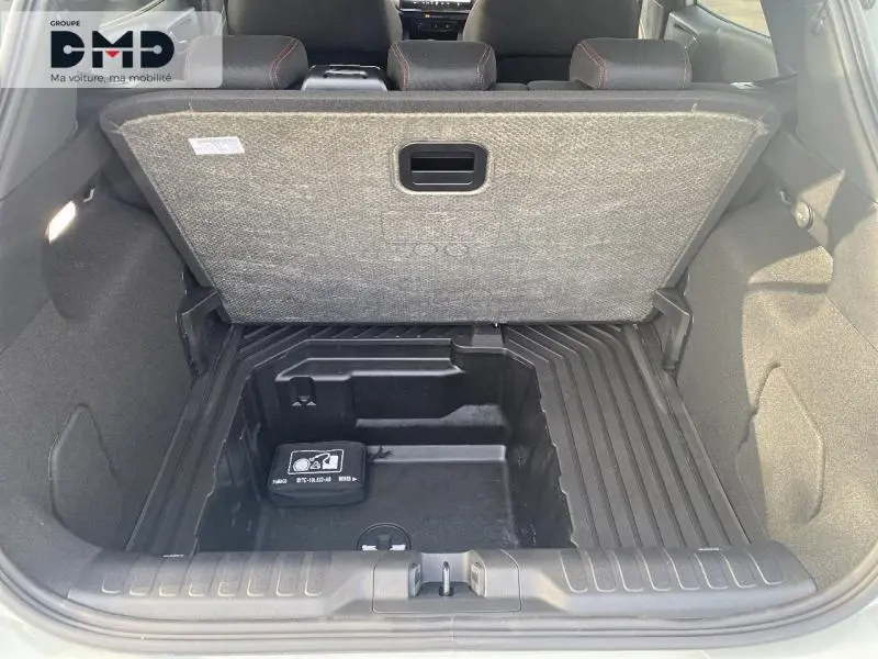 Coffre ouvert d'une Ford Puma gris Cactus montrant le rangement sous plancher et la trousse de secours.