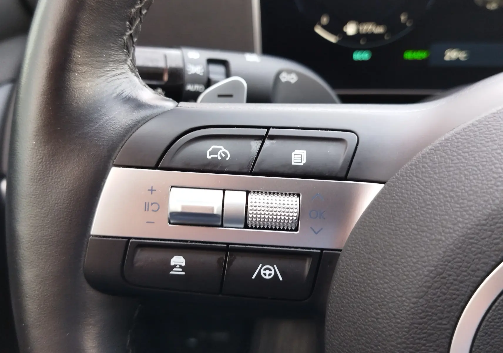 Gros plan sur les commandes multifonctions côté gauche du volant du Hyundai Tucson 2024, finition Ultimate Red Métal.