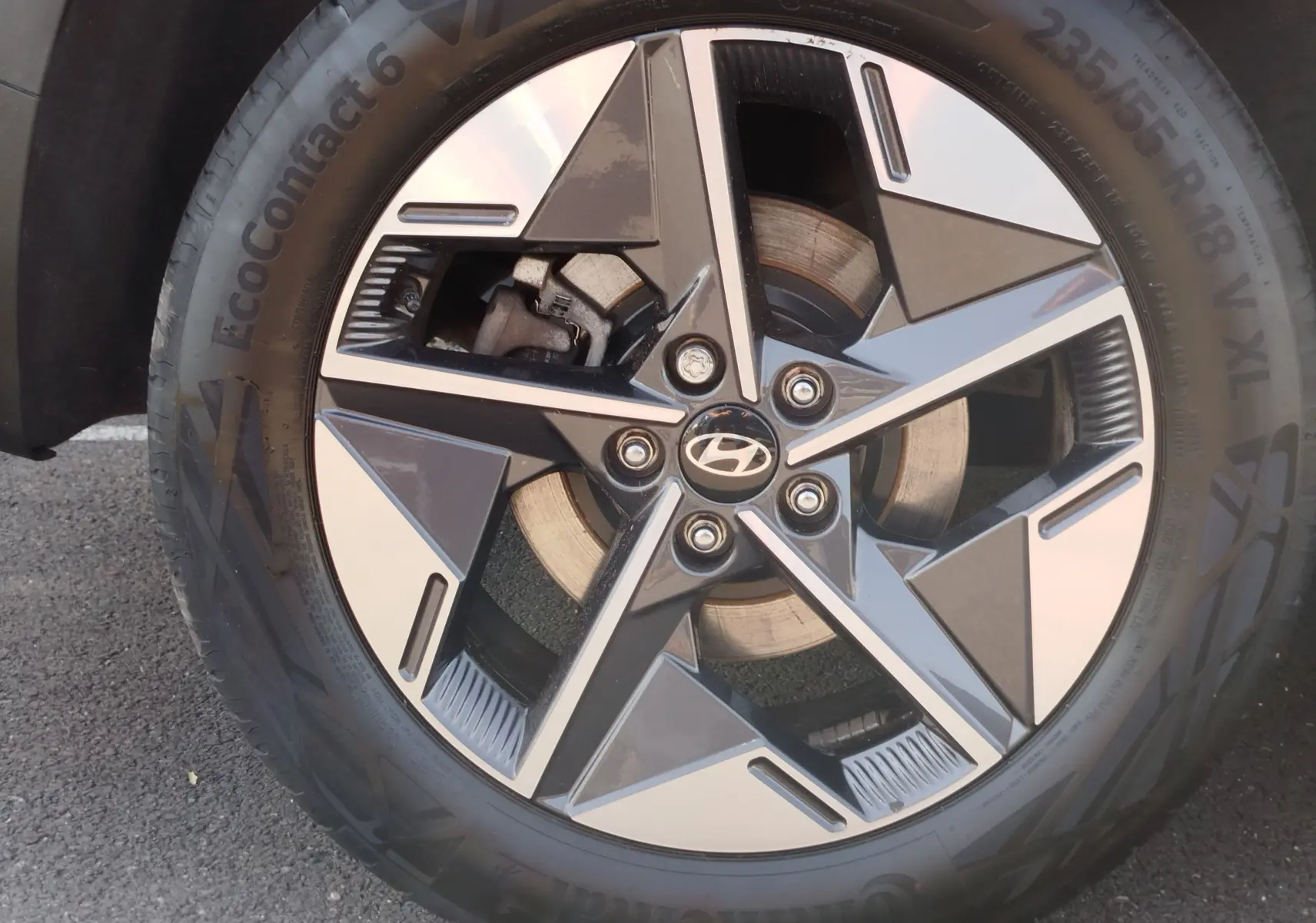 Gros plan sur la jante bi-ton noire et argentée avec logo Hyundai au centre, montée sur un pneu Continental.