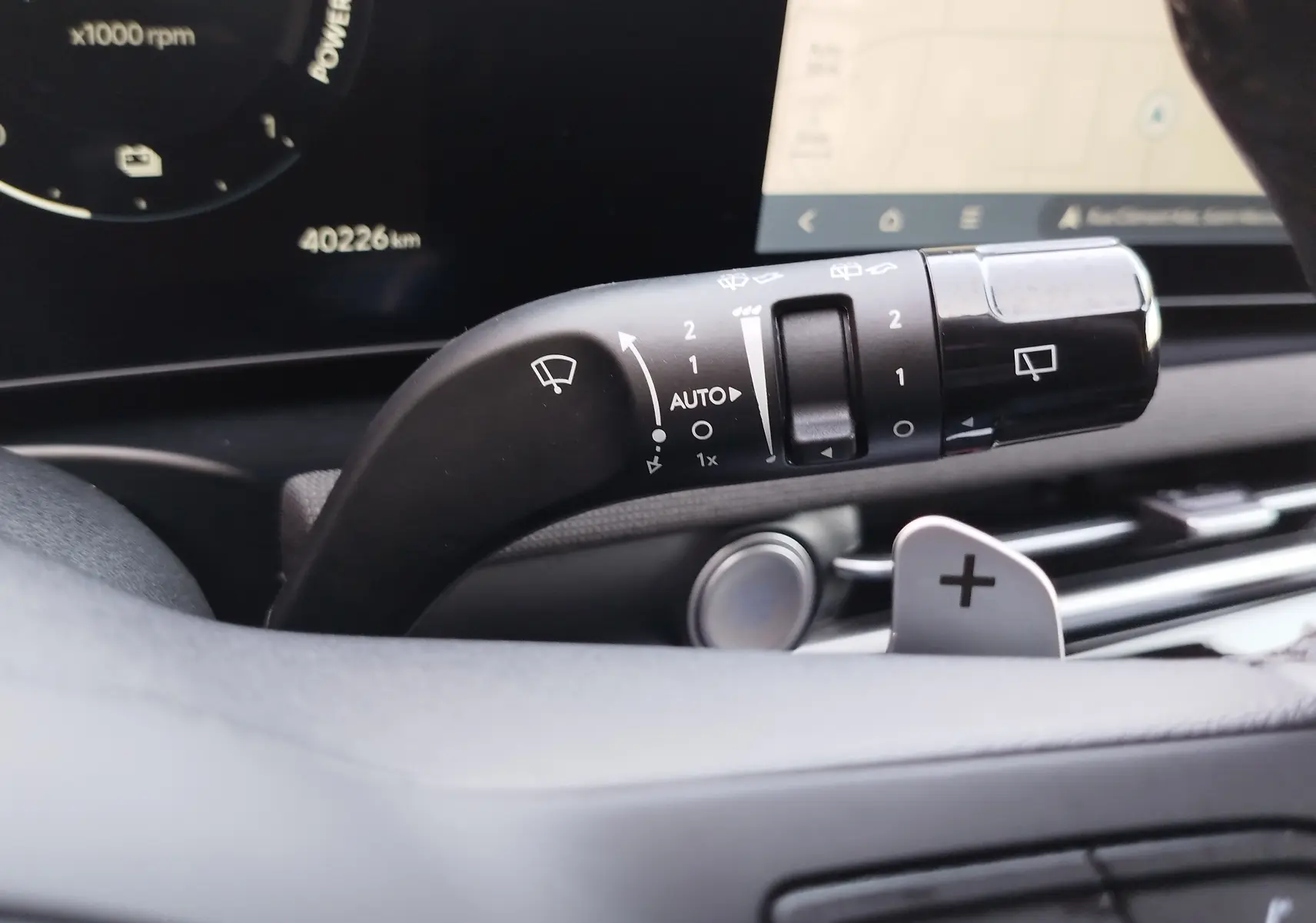 Gros plan sur la manette d’essuie-glace du Hyundai Tucson 2024, avec tableau de bord numérique en arrière-plan.