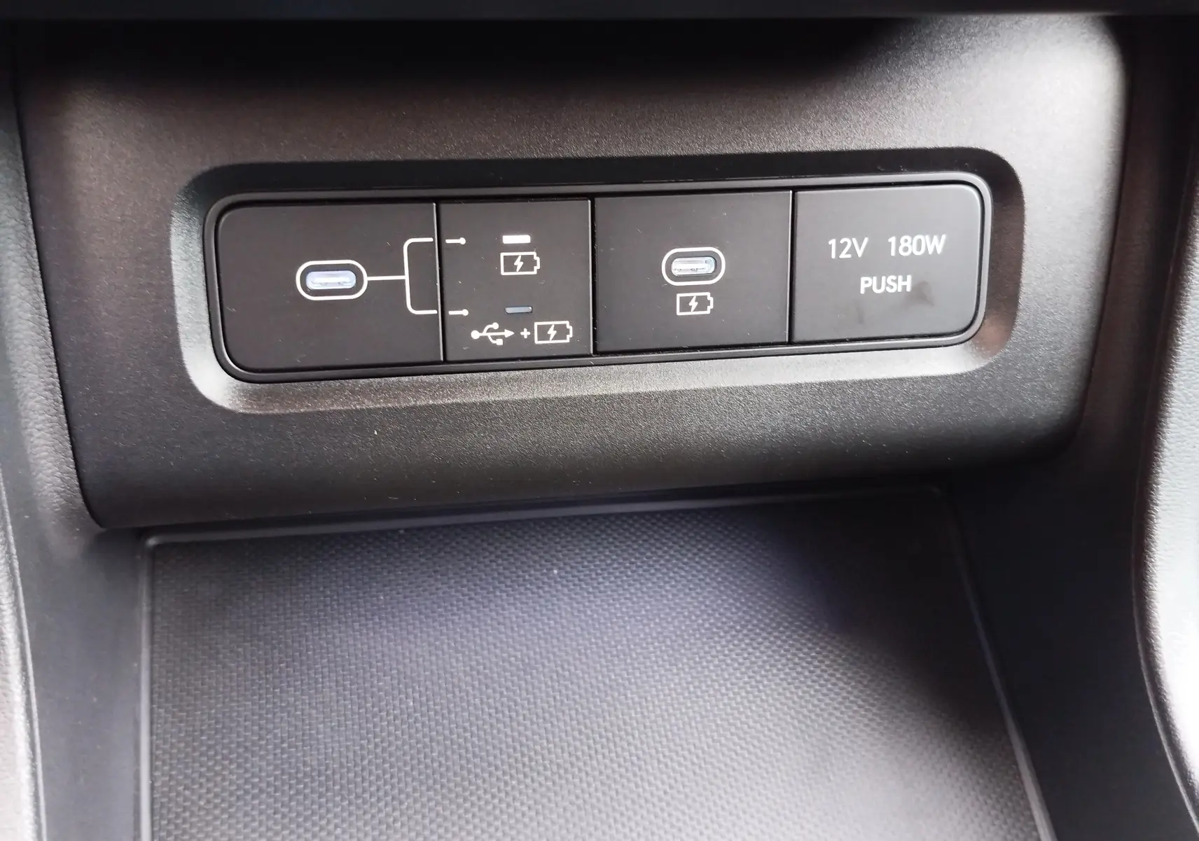 Gros plan sur les ports USB-C et prise 12V noirs du tableau de bord du Hyundai Tucson 2024 hybride.