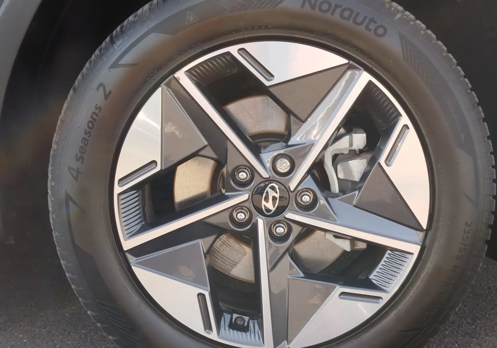 Gros plan sur la jante alliage bi-ton du Hyundai Tucson 2024, avec logo Hyundai au centre et pneu 4 Seasons visible.