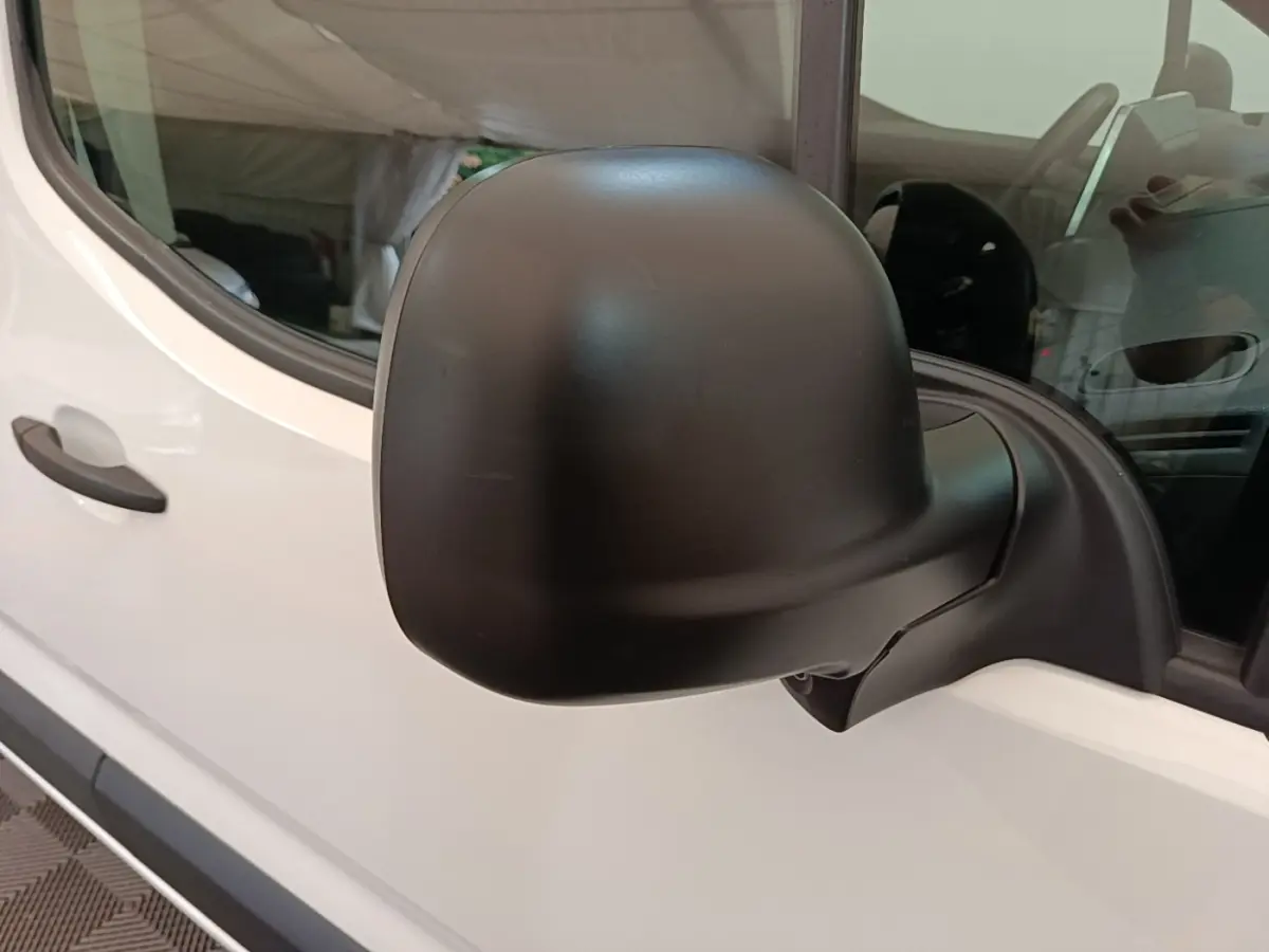 Gros plan sur le rétroviseur noir côté conducteur d'un Citroën Berlingo XL blanc, vue latérale gauche.