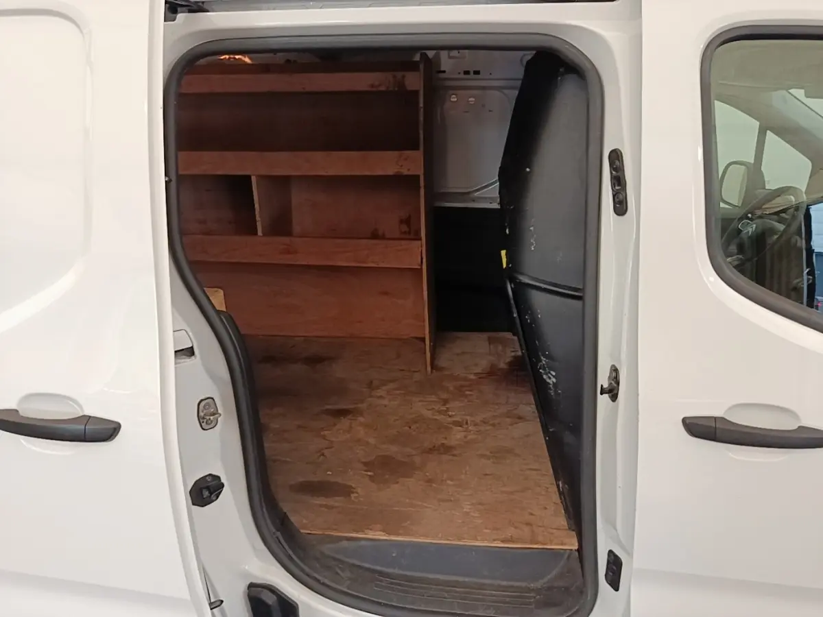 Vue latérale droite d’un Citroën Berlingo blanc 2020 avec porte coulissante ouverte montrant l’espace de chargement aménagé en bois.