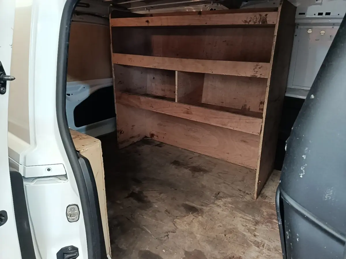 Vue intérieure arrière du Citroën Berlingo blanc 2020 avec aménagement bois de rangement dans l’espace de chargement.