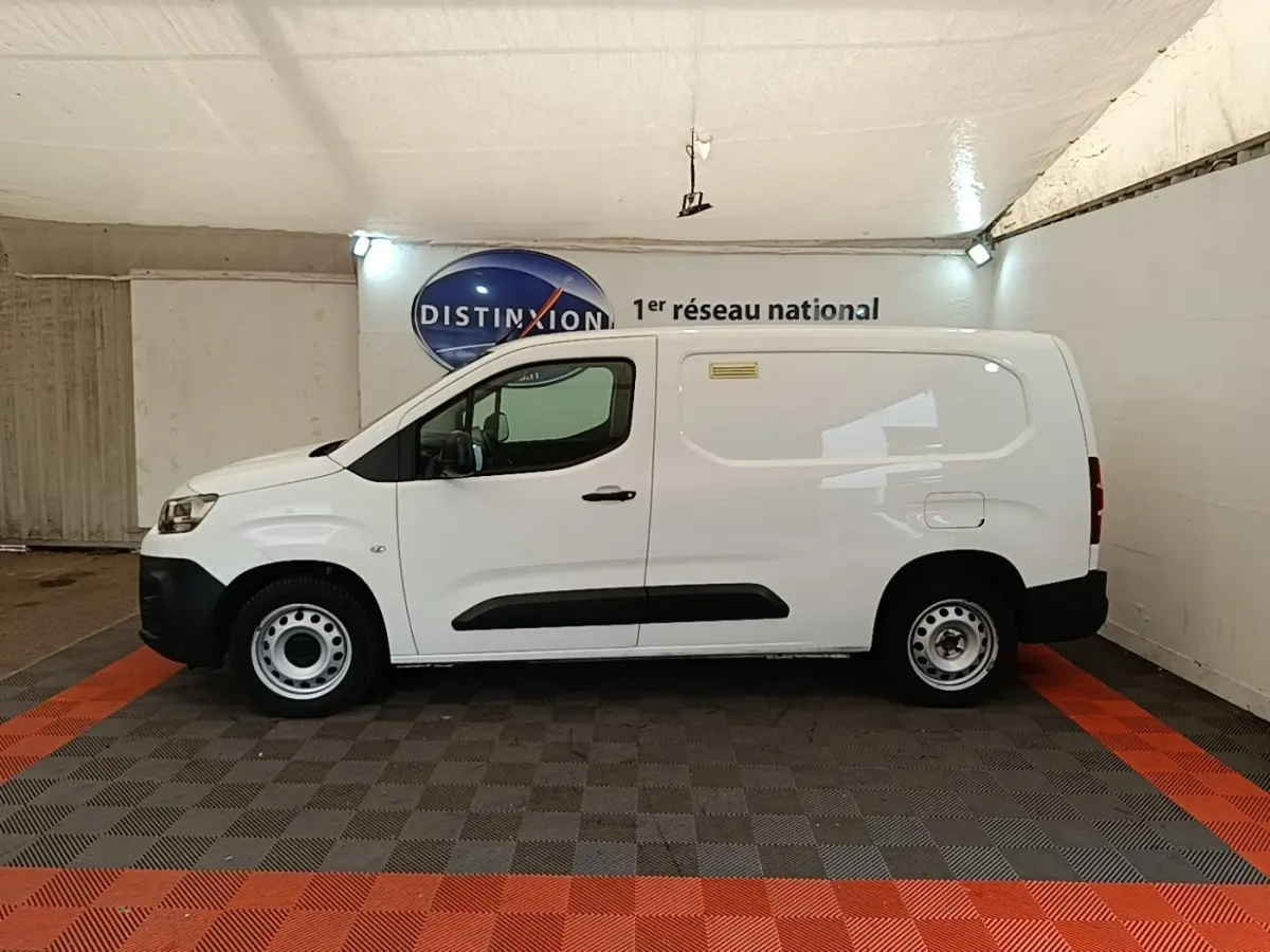 Vue de profil côté gauche d’un utilitaire Citroën Berlingo XL blanc avec jantes acier et protections noires sur les portes.