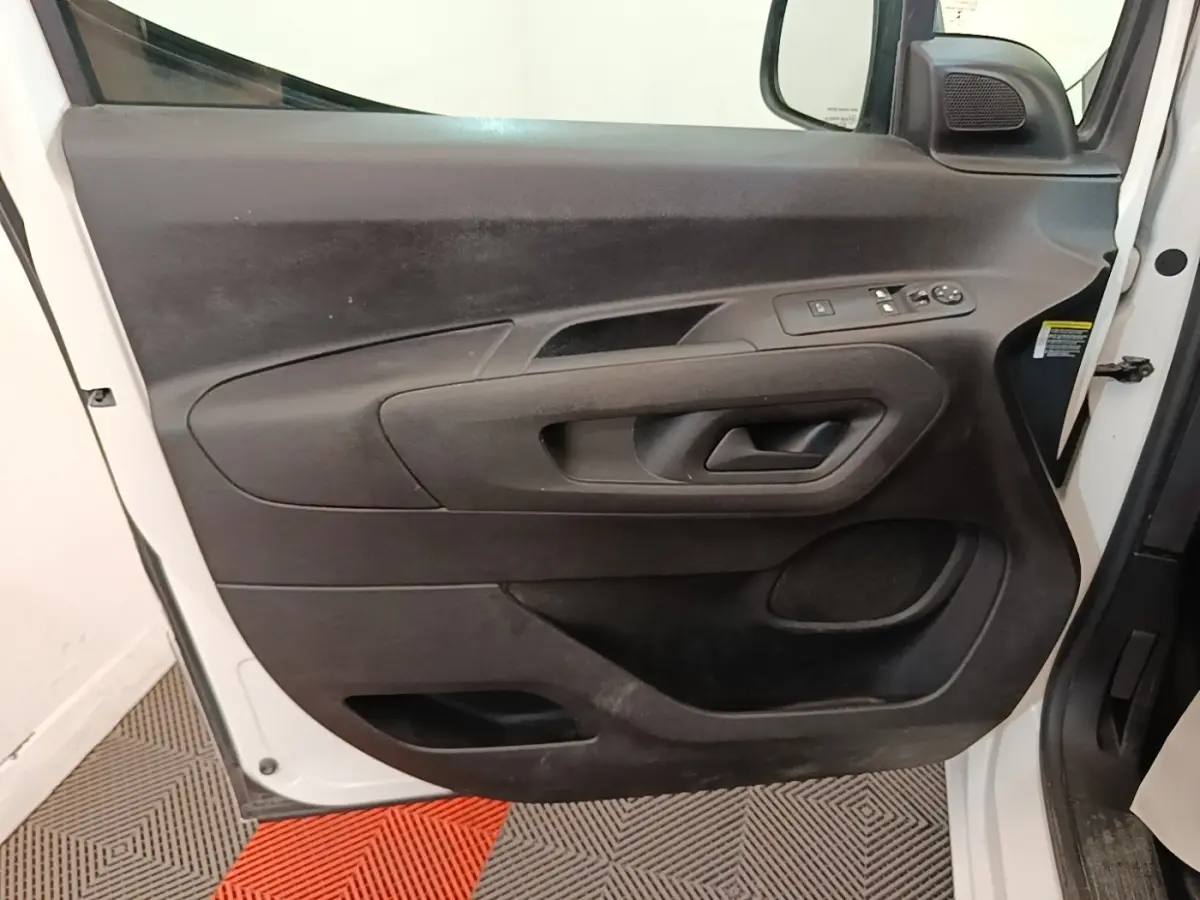 Vue rapprochée de la porte avant gauche blanche du Citroën Berlingo XL 2020 avec commandes électriques et haut-parleur intégré.