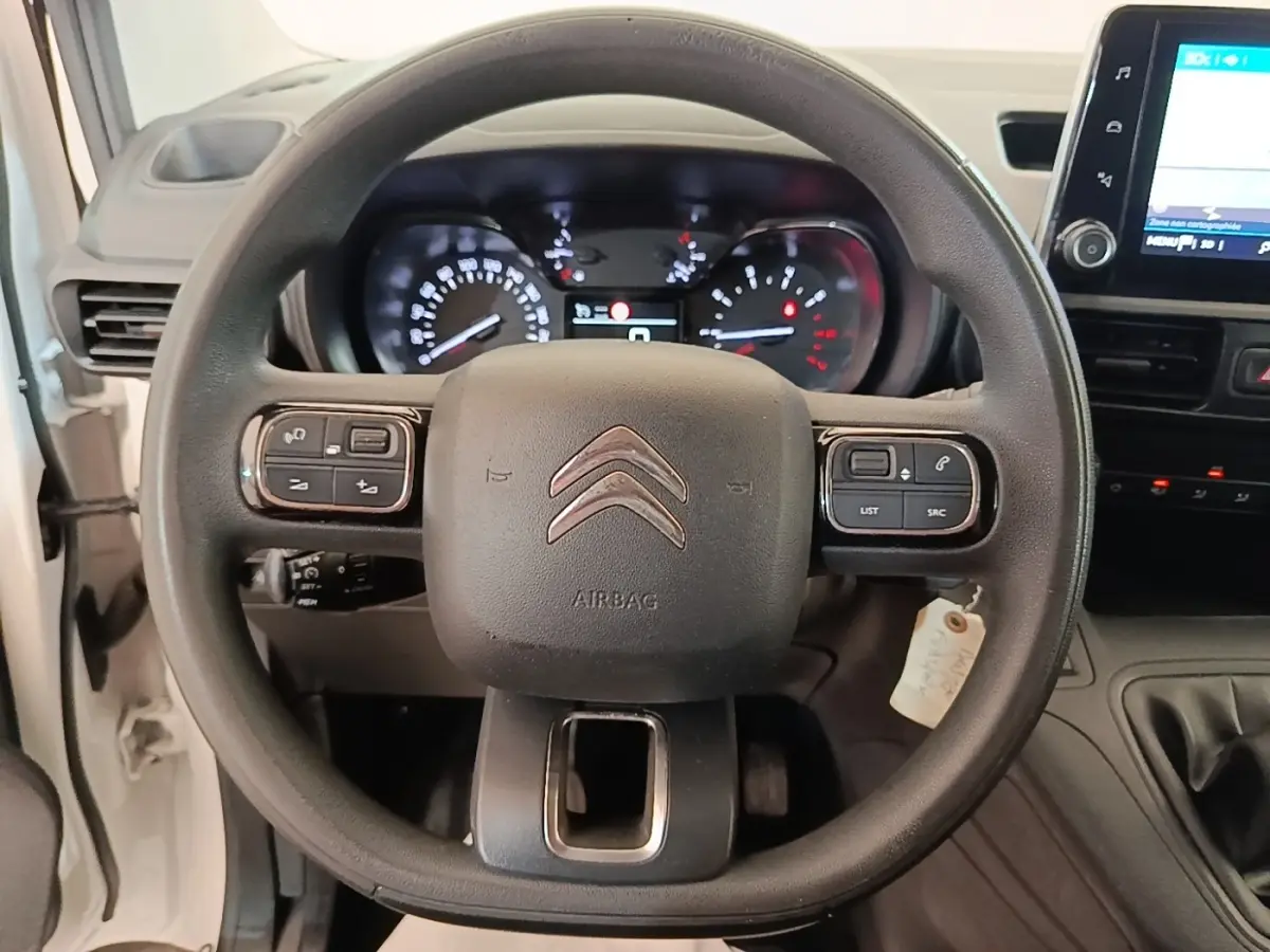 Vue rapprochée du volant multifonctions noir et du tableau de bord numérique du Citroën Berlingo XL blanc de 2020.