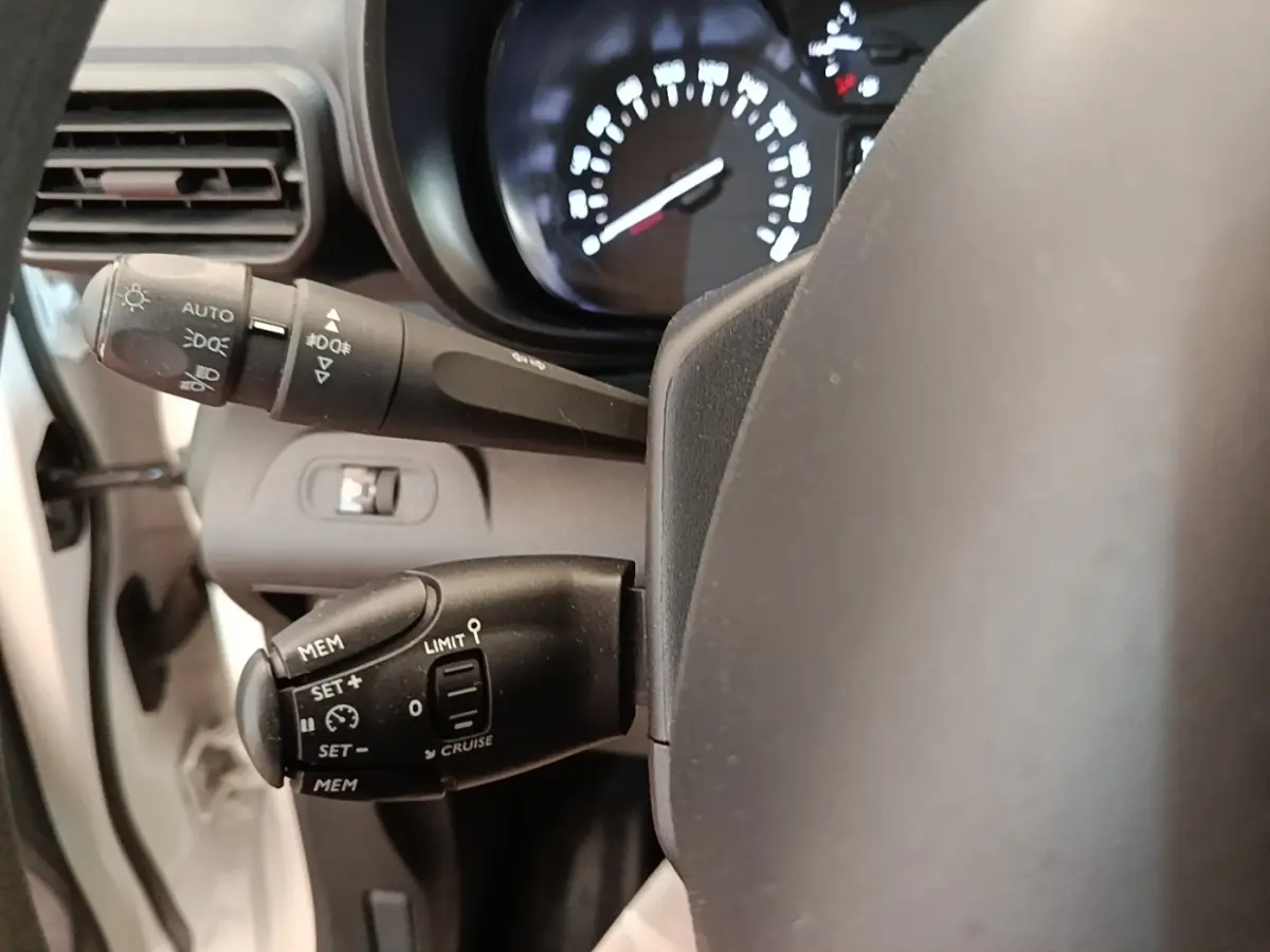 Gros plan sur la commande de régulateur de vitesse et limiteur, volant partiel de Citroën Berlingo blanc 2020.