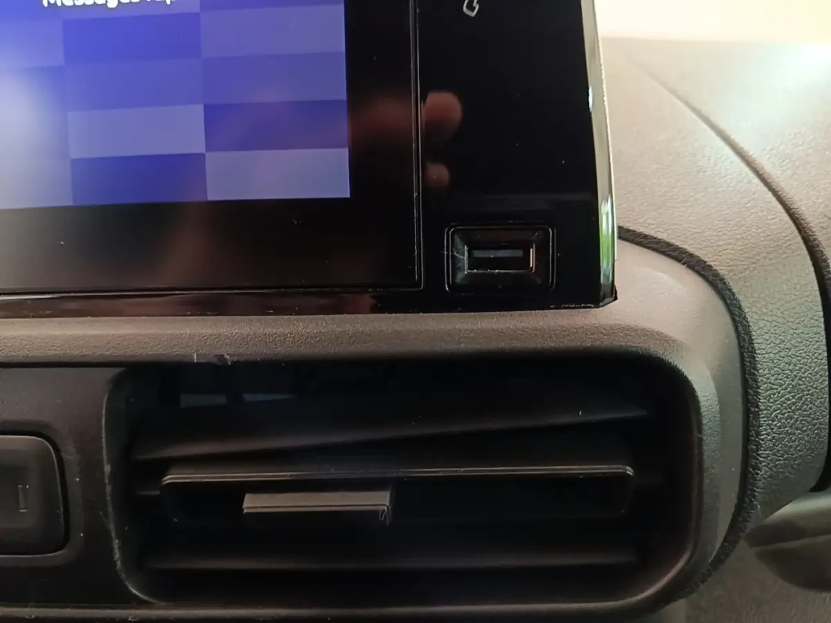 Gros plan sur la console centrale noire du Citroën Berlingo XL 2020, montrant l'écran tactile et une sortie d'air.