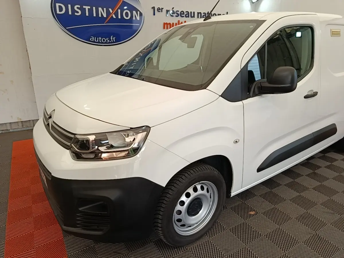 Vue 3/4 avant droit du Citroën Berlingo XL blanc, avec pare-chocs noir et jantes acier simples.