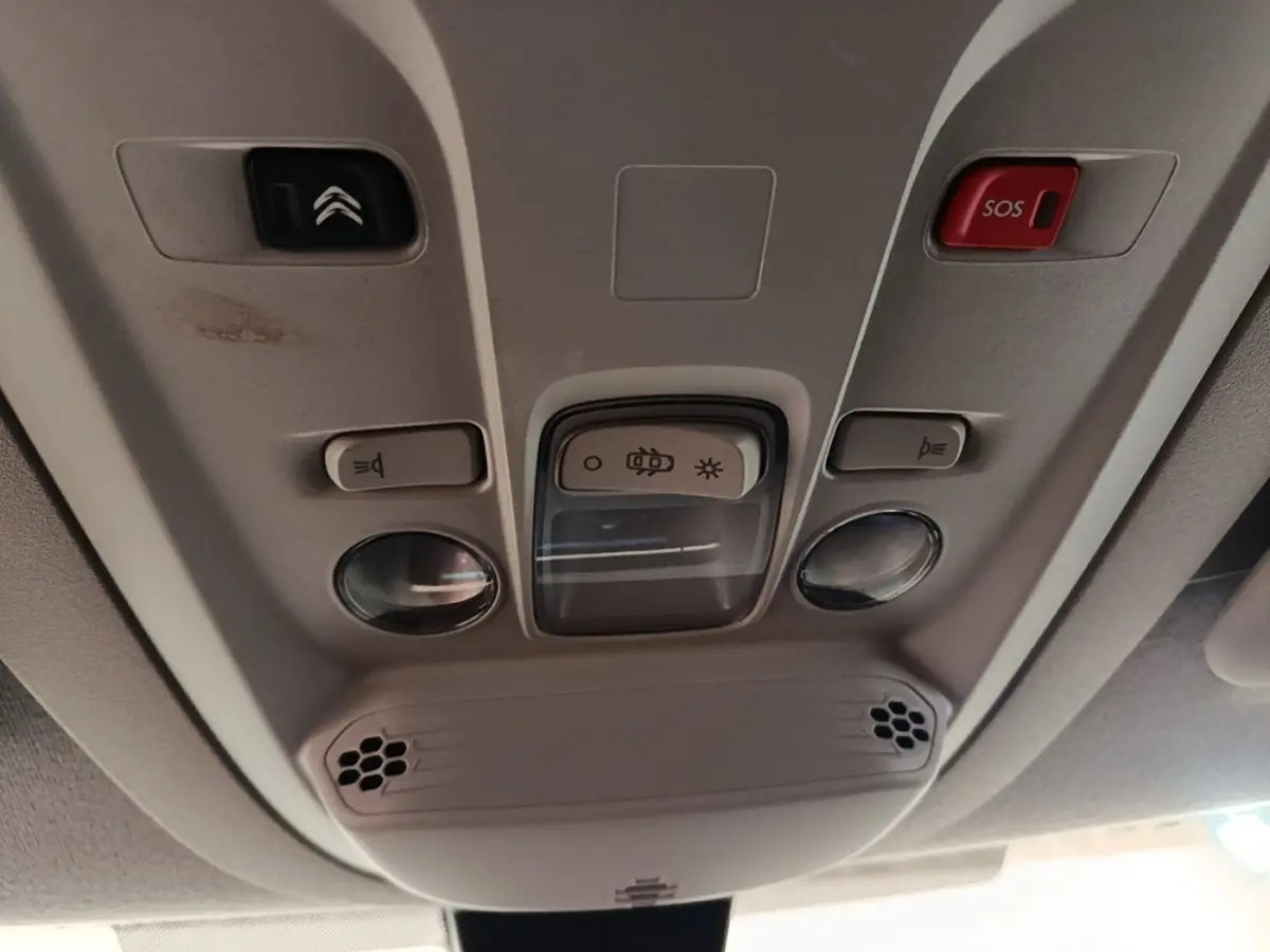 Vue intérieure du plafonnier gris clair du Citroën Berlingo XL 2020 avec boutons d’éclairage et alarme SOS.