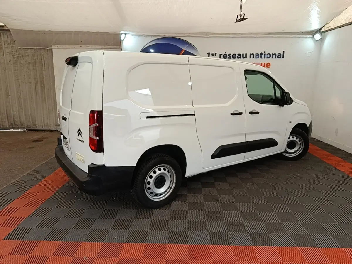 Vue 3/4 arrière droite d’un Citroën Berlingo XL blanc avec jantes acier et protections latérales noires.