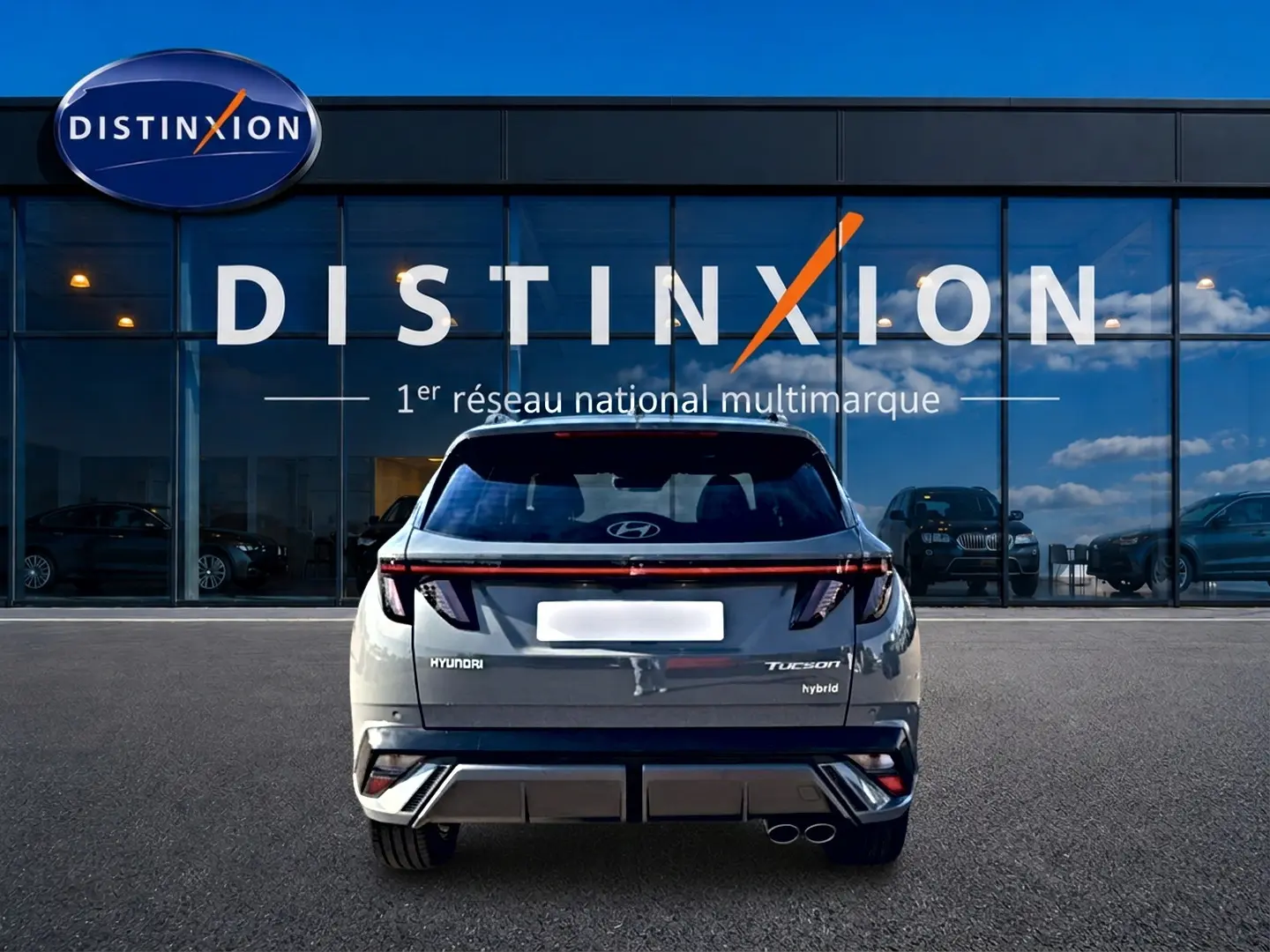 Vue arrière d’un Hyundai Tucson gris shadow hybride 2026, avec feux LED et double sortie d’échappement visible.