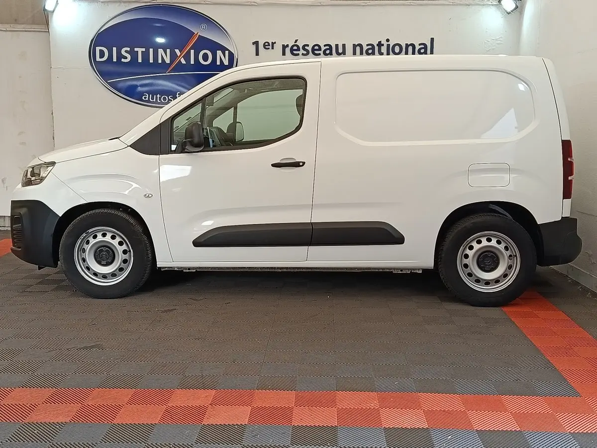 Vue latérale droite d’un utilitaire Citroën Berlingo blanc 2020 avec jantes acier et bande de protection noire sur porte.