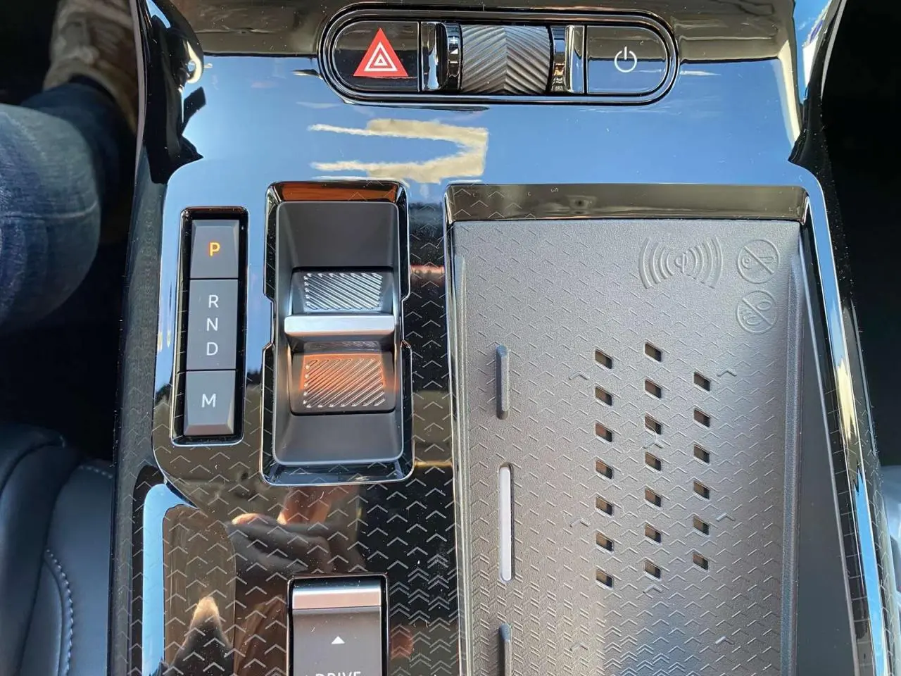 Gros plan sur la console centrale noire brillante du Citroën C5 Aircross hybride, avec sélecteur de vitesses et commandes tactiles.