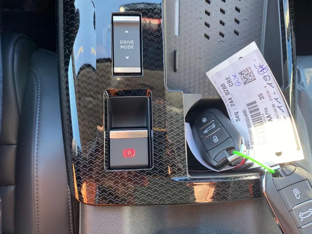 Gros plan sur la console centrale noire du Citroën C5 Aircross 2026 avec boutons Drive Mode et frein à main électronique.