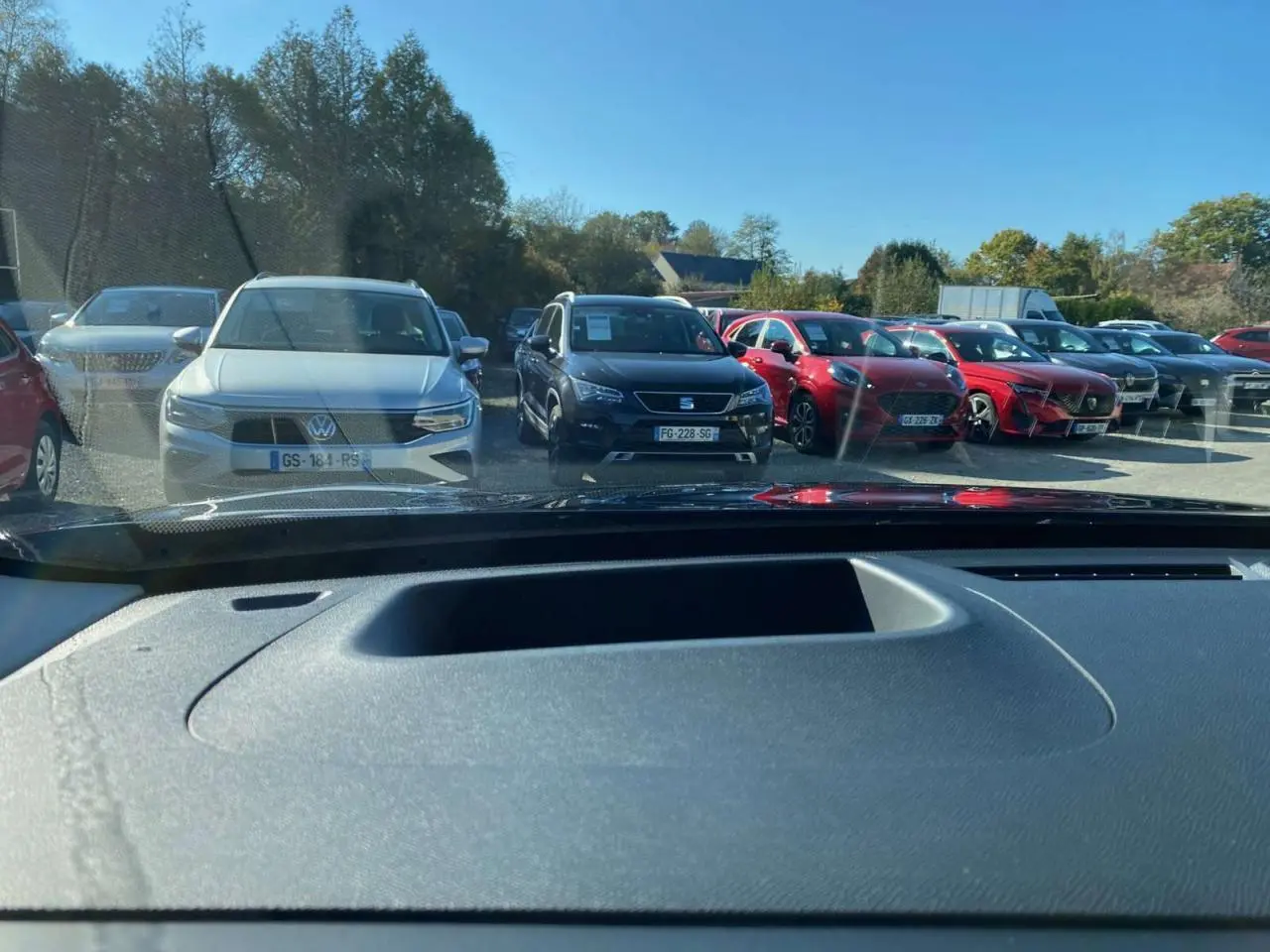 Vue depuis l'intérieur montrant le tableau de bord et le pare-brise, avec un Citroën C5 Aircross noir visible à l'extérieur.