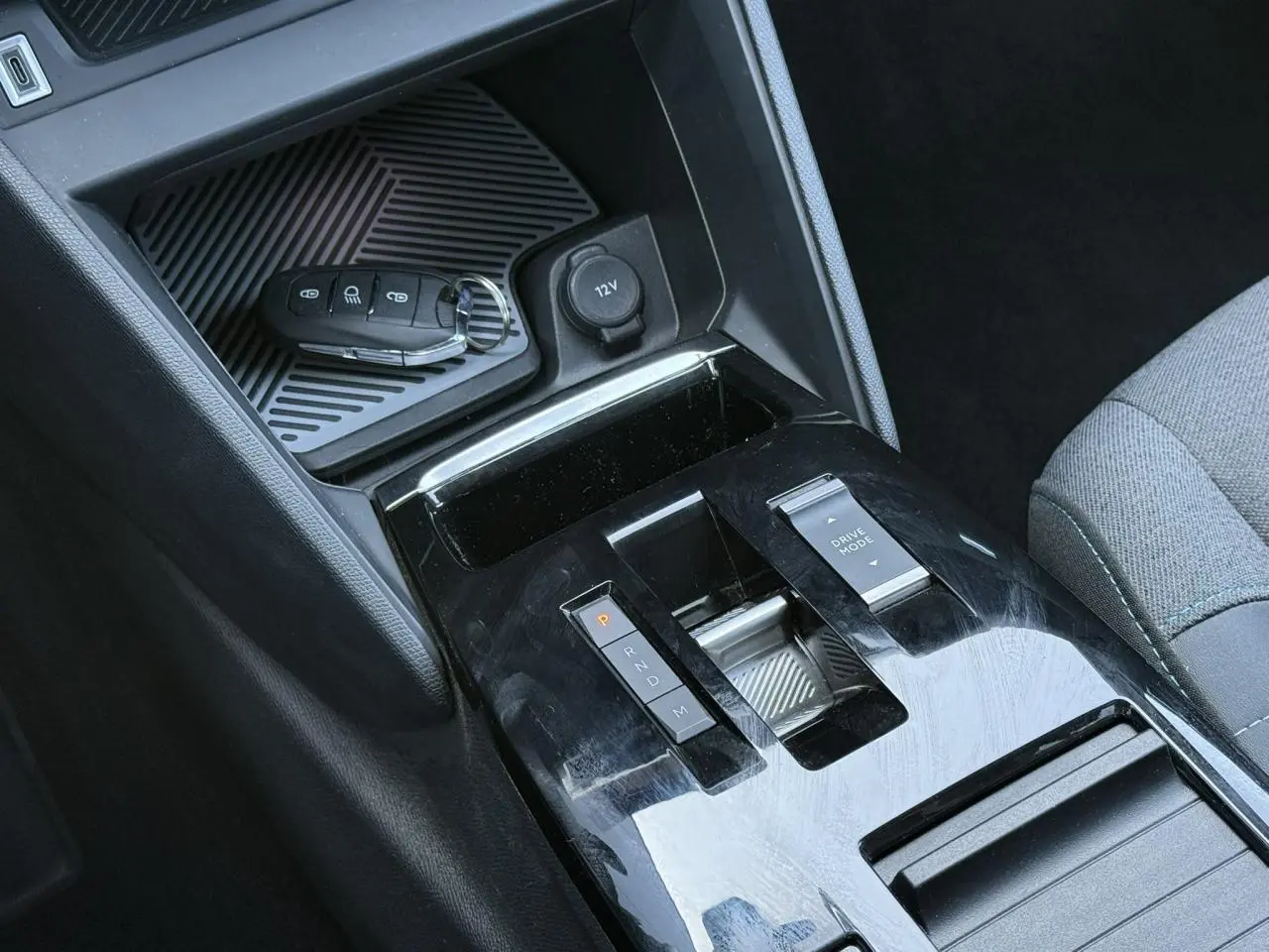 Gros plan sur la console centrale noire brillante de la Citroën C4 X 2024 avec clé et commandes de boîte auto.