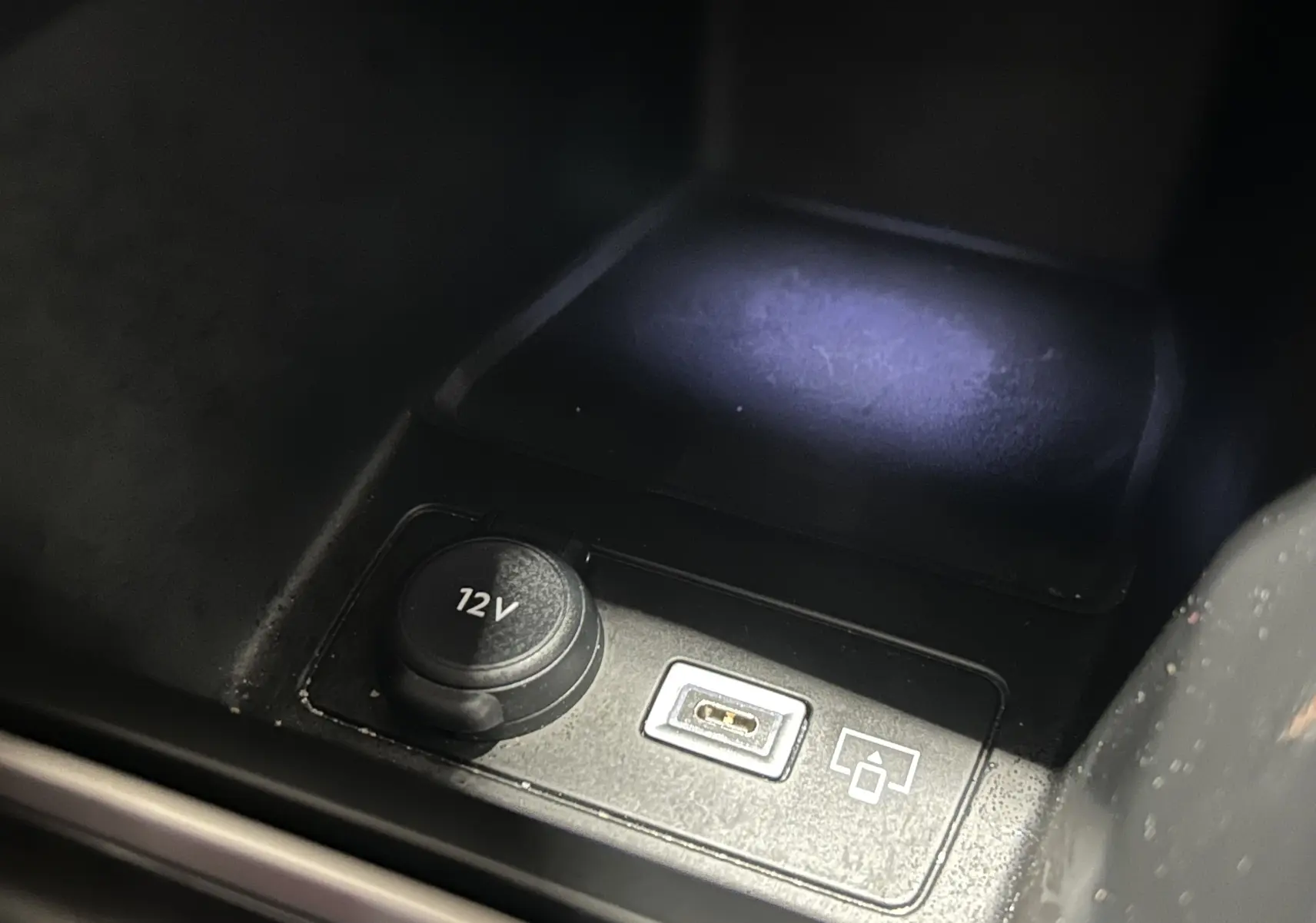 Détail intérieur montrant une prise 12V et un port USB dans une Peugeot 308 rouge de 2024.