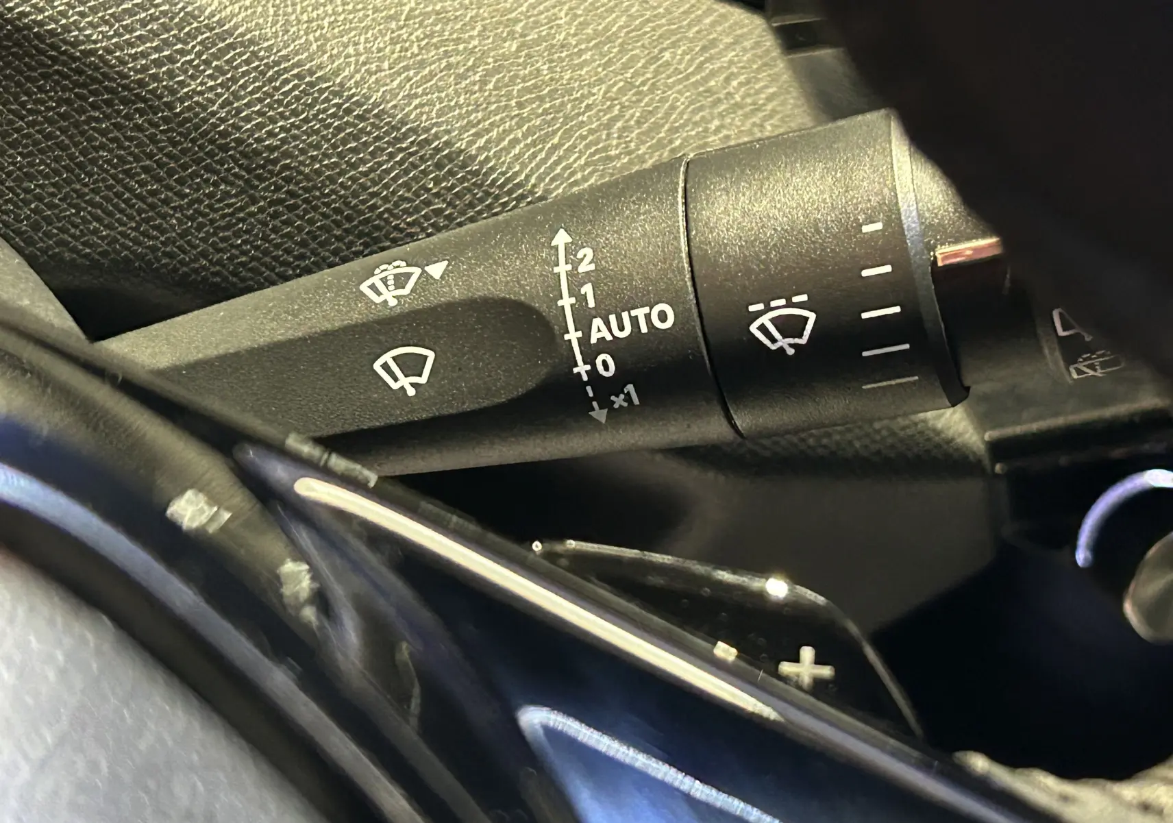 Gros plan sur la commande d’essuie-glace de la Peugeot 308 rouge 2024, montrant les réglages automatiques.