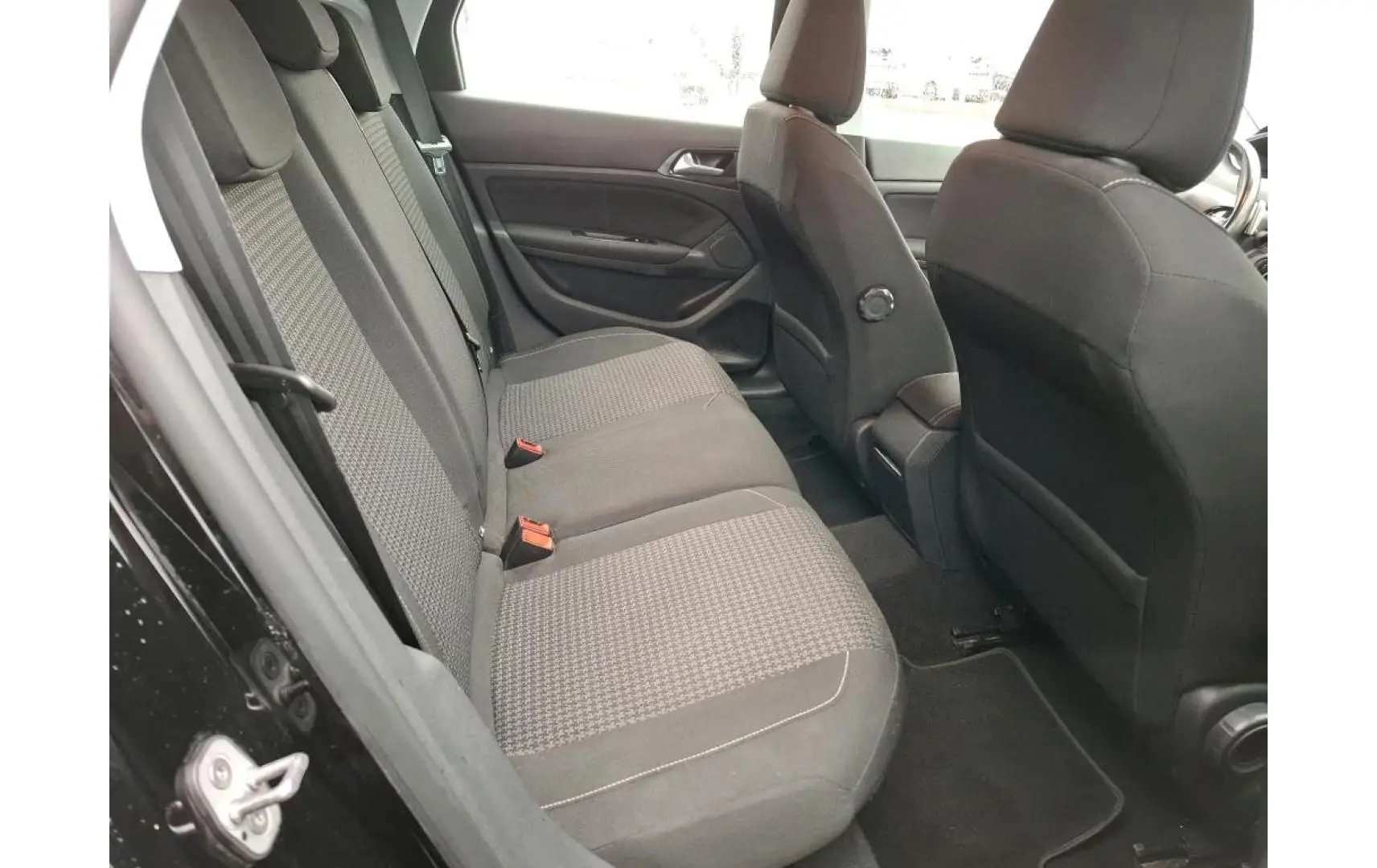 Vue intérieure côté gauche montrant la banquette arrière en tissu gris et noir du Peugeot 308 SW noir de 2021.