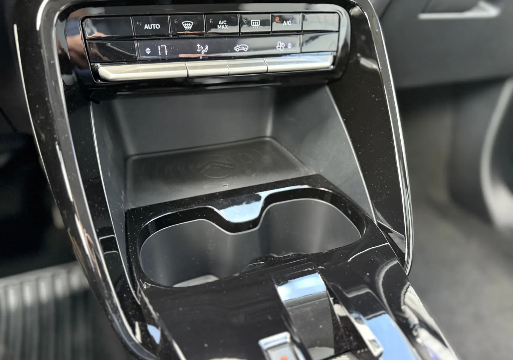 Détail de la console centrale noire du Citroën C3 Aircross Hybrid 145, avec commandes climatisation et porte-gobelets.