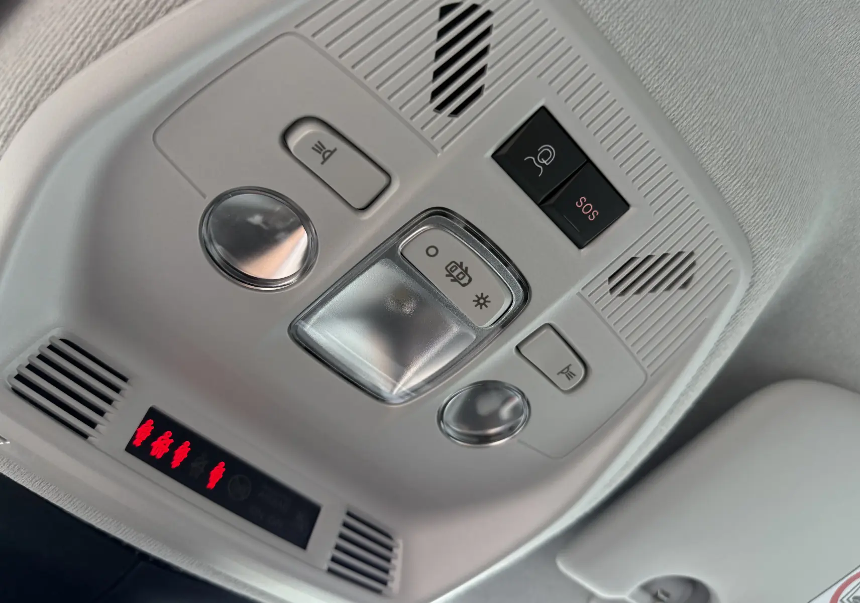 Vue en gros plan du plafonnier intérieur gris clair avec boutons d’éclairage et alerte SOS dans une Citroën C3 Aircross blanc banquise toit noir.