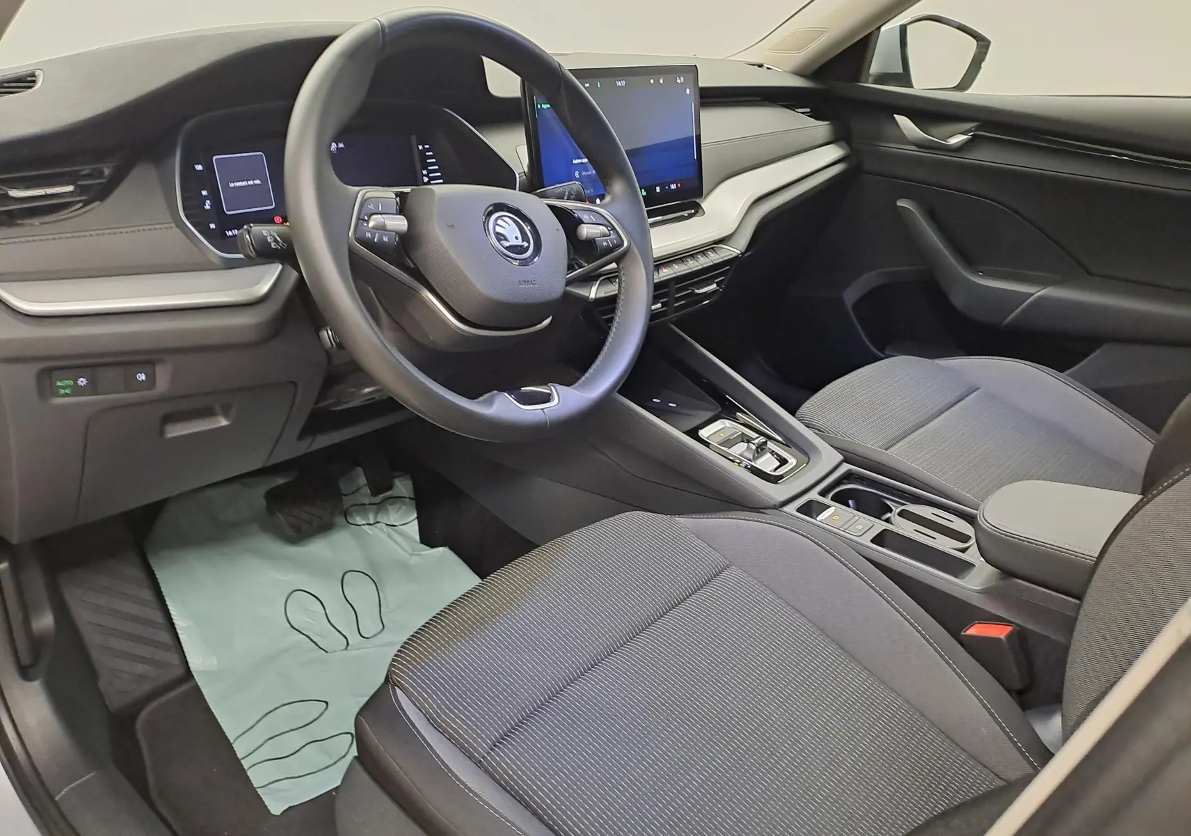 Vue intérieure côté conducteur de la Skoda Octavia Combi 2025, tableau de bord moderne avec écran tactile central et volant multifonction.