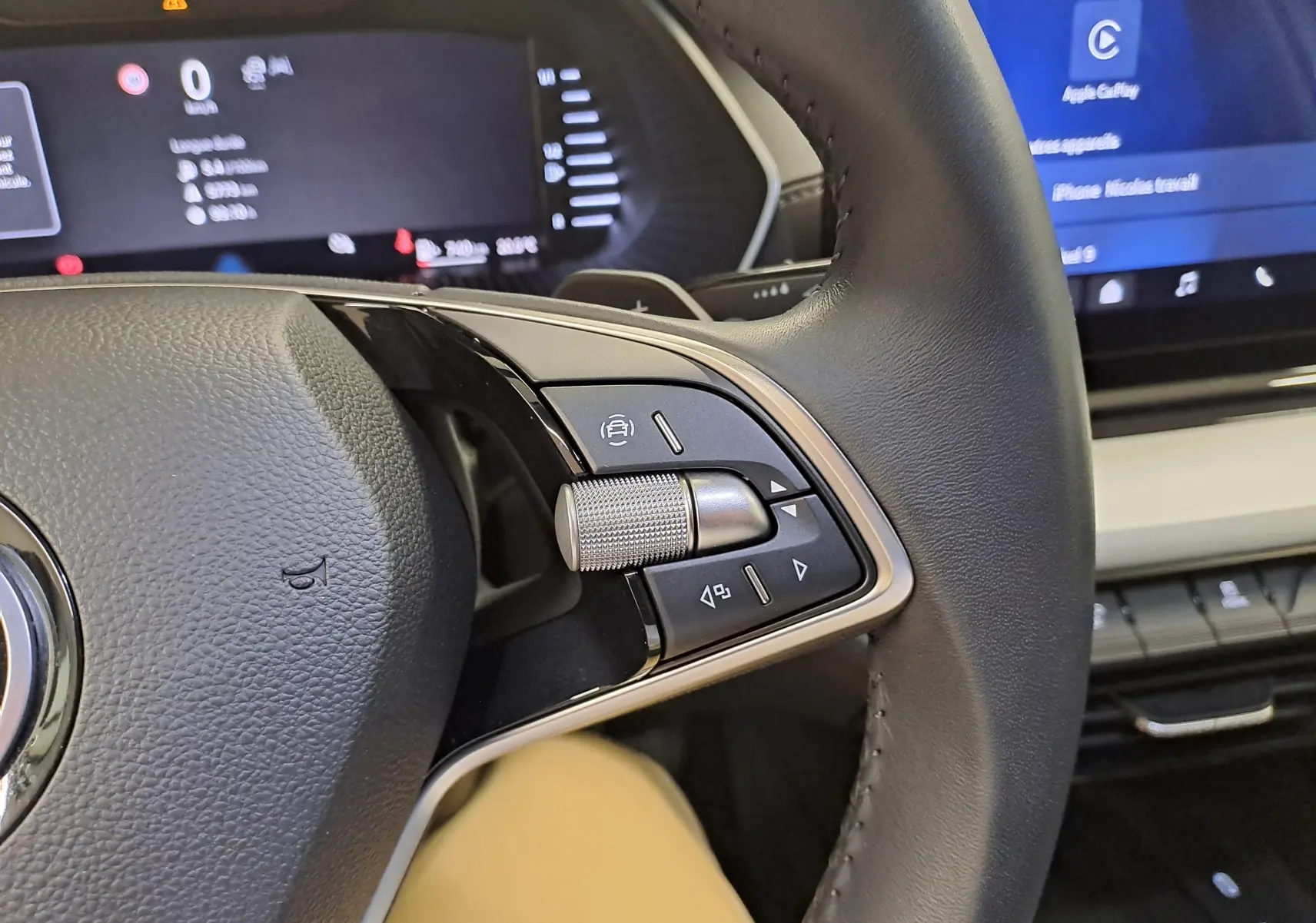Gros plan sur la partie droite du volant noir du Skoda Octavia Combi 2025 avec commandes intégrées et tableau de bord numérique.