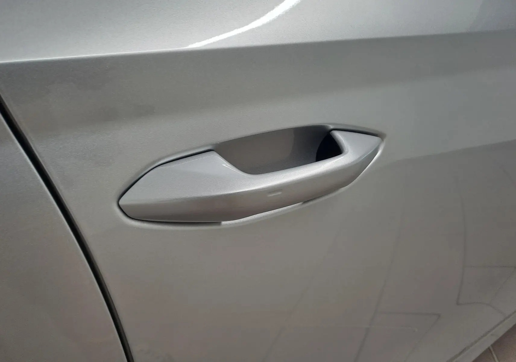 Poignée de porte gris argentée en gros plan sur une SKODA OCTAVIA COMBI 2025 côté gauche.