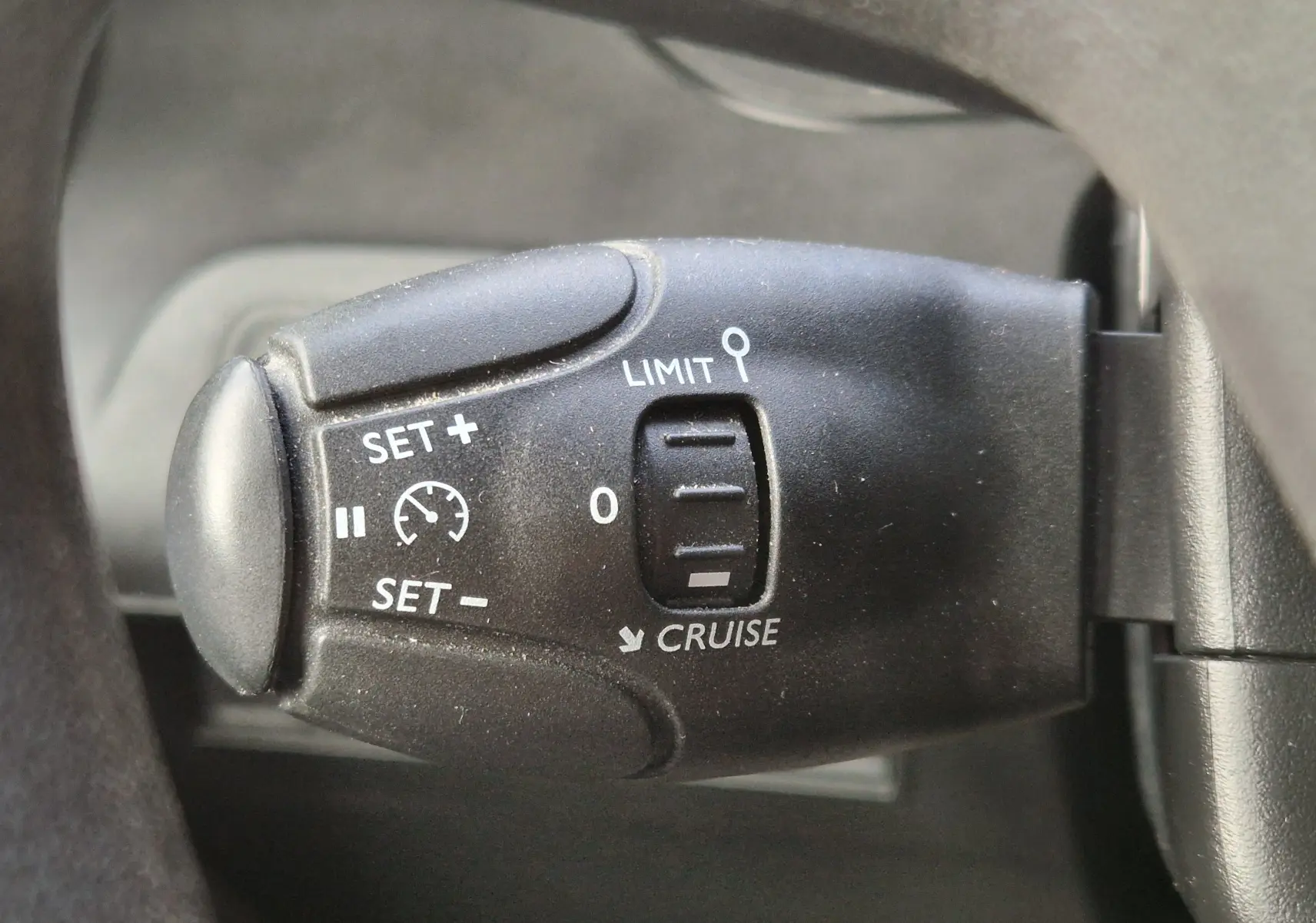 Gros plan sur la commande de régulateur de vitesse noire du Peugeot Partner Long 2021, avec inscriptions blanches visibles.