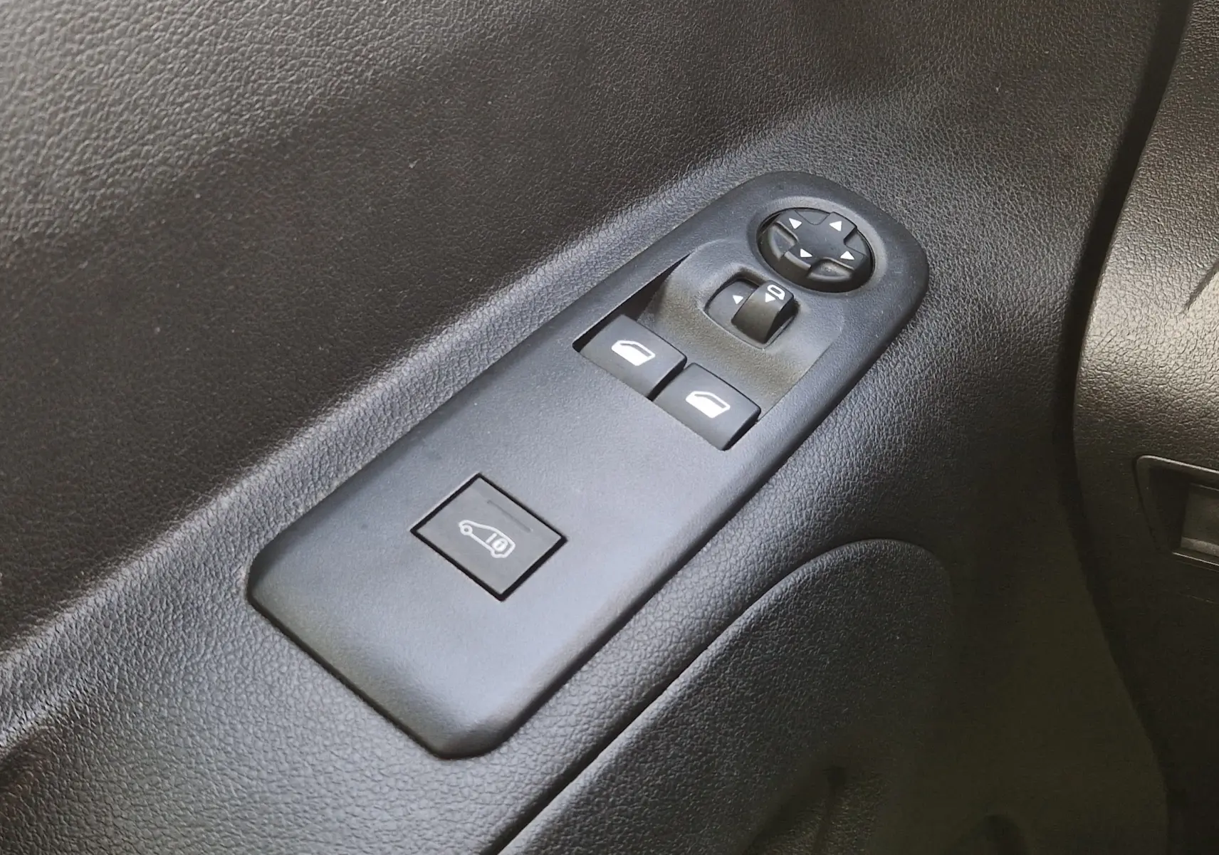 Gros plan sur les commandes de lève-vitres et réglage des rétroviseurs côté conducteur du Peugeot Partner blanc 2021.