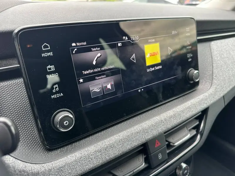 Écran tactile central de la Skoda Scala 2025 en noir Magic nacré, affichant interface multimédia et commandes audio.