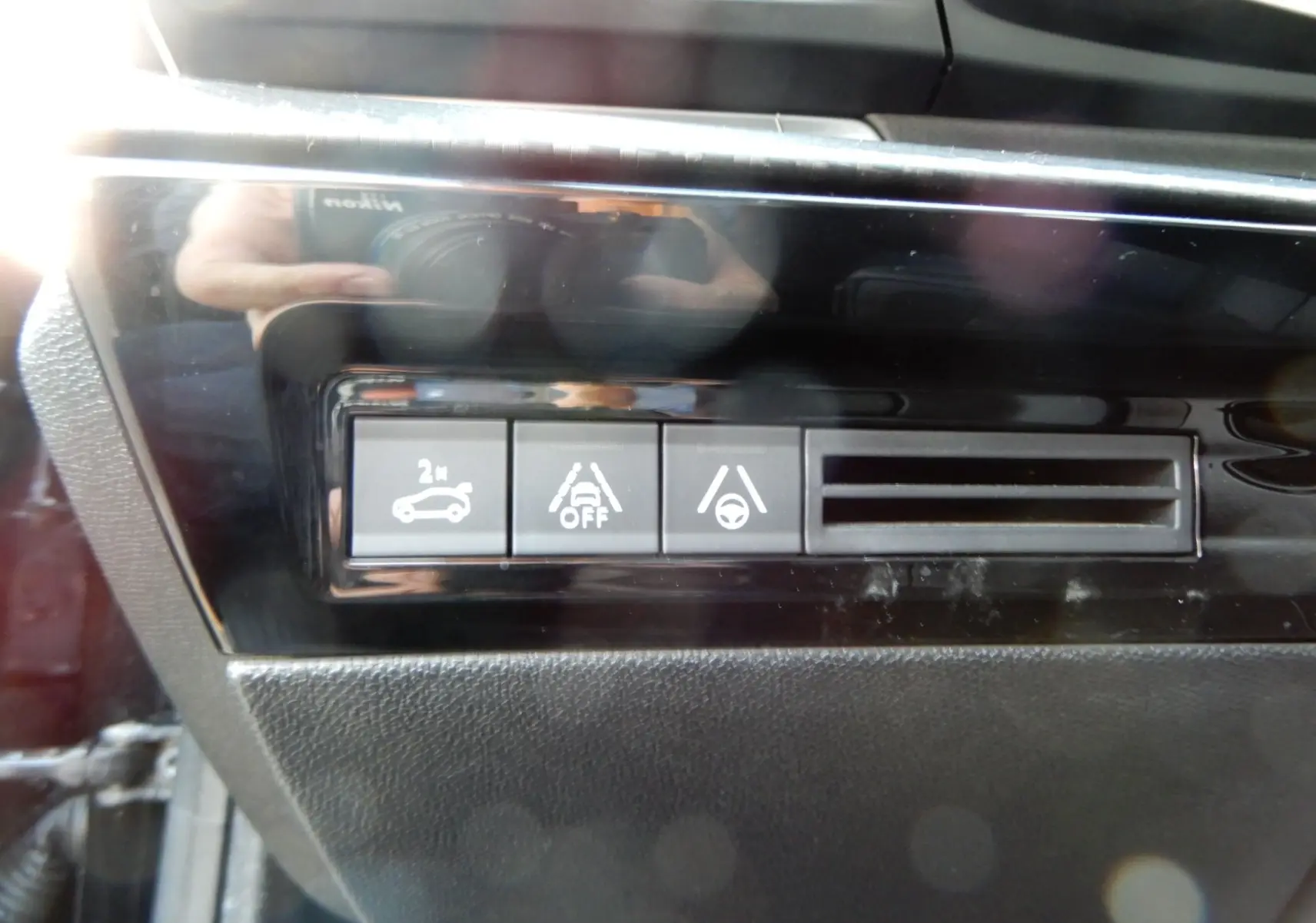 Gros plan sur les boutons de contrôle d’aide à la conduite dans l’habitacle d’une Peugeot 508 SW noire.