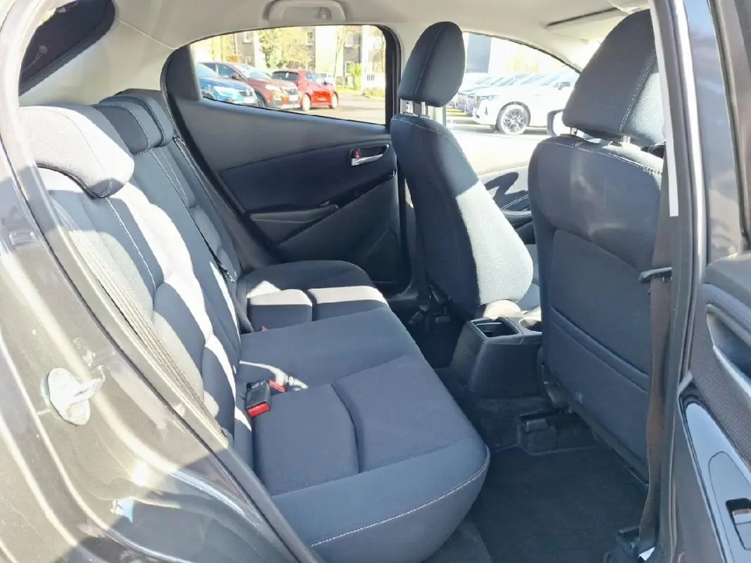 Vue intérieure côté droit sur les sièges arrière noirs d'une Mazda2 gris 2023, avec porte ouverte.