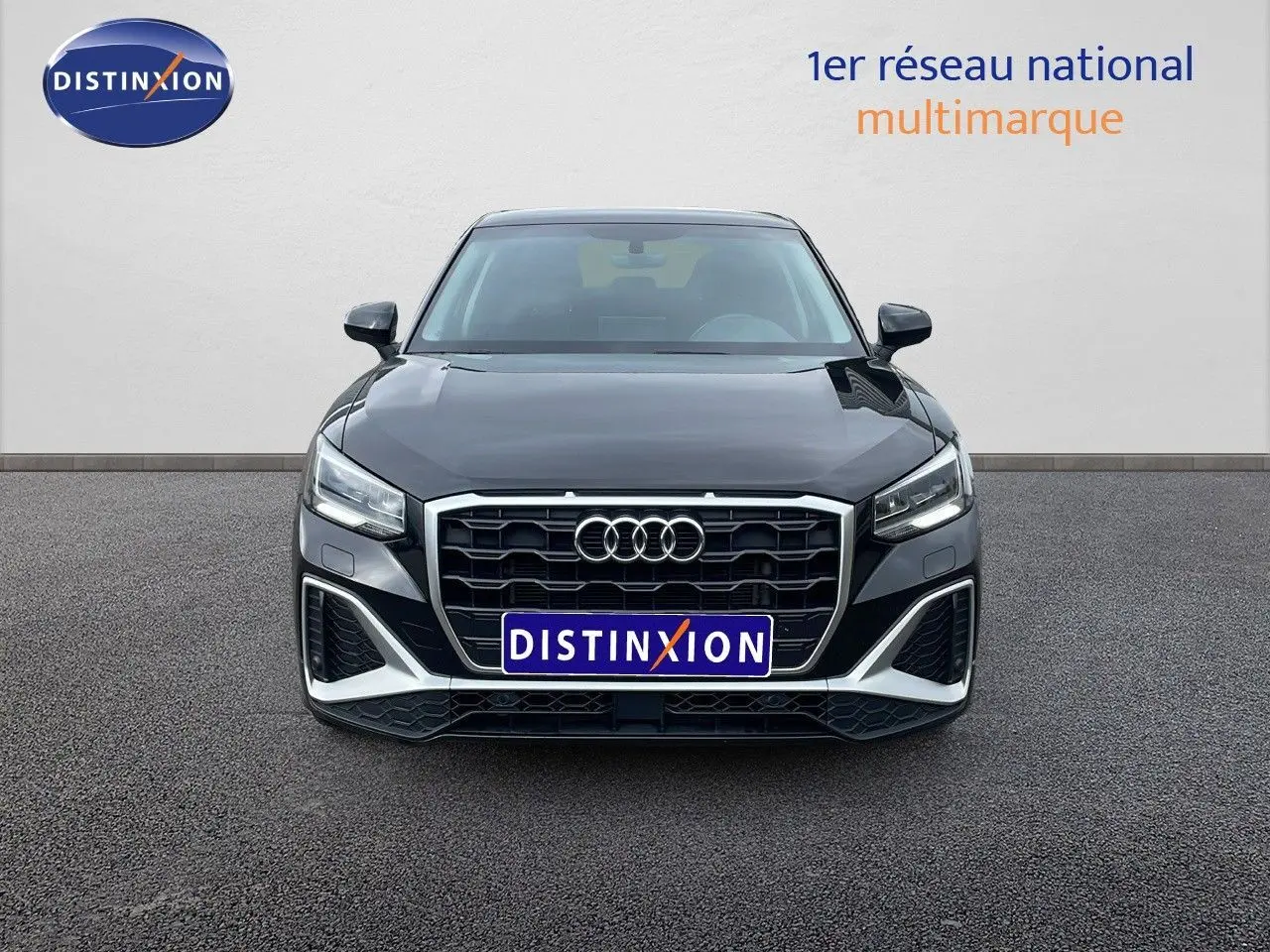 Vue frontale d'un Audi Q2 noir mito metal 2023 avec calandre hexagonale et phares LED distinctifs.