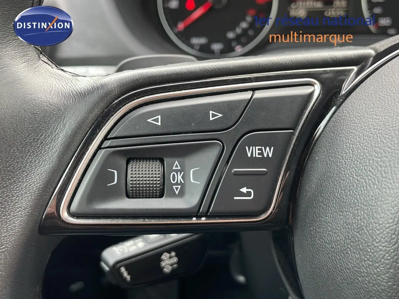 Gros plan sur les commandes multifonctions au volant en cuir noir de l'Audi Q2 35 TFSI S-Line 2023.