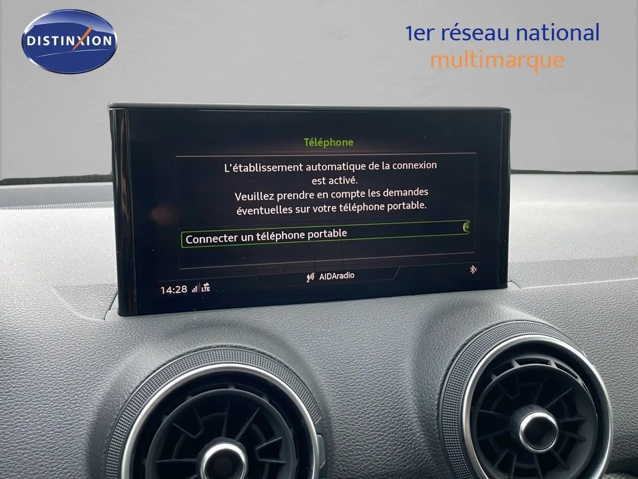 Écran central affichant la connexion Bluetooth dans l'habitacle d'un Audi Q2 noir mito metal, vue de face.