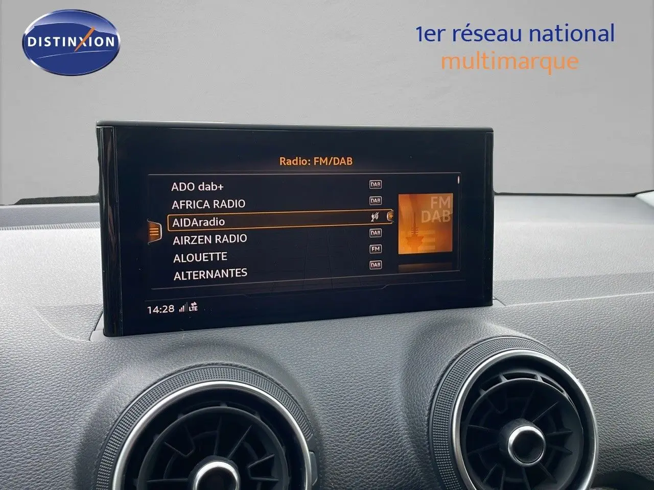 Écran central affichant les stations radio FM/DAB dans l'habitacle d'un Audi Q2 noir Mito Metal 2023.