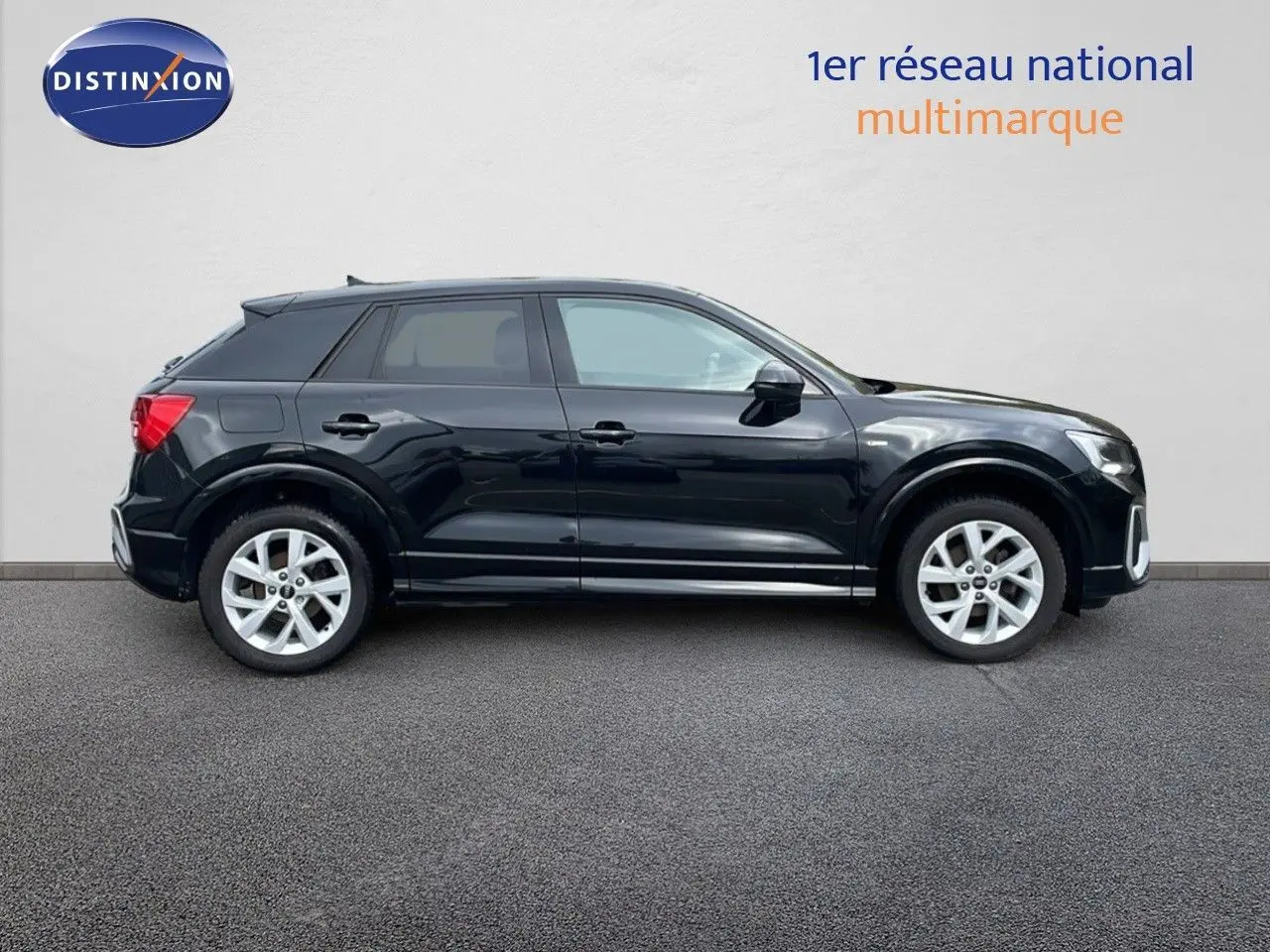 Profil côté gauche d'un Audi Q2 35 TFSI S-Line noir mito metal avec jantes alliage et lignes dynamiques visibles.