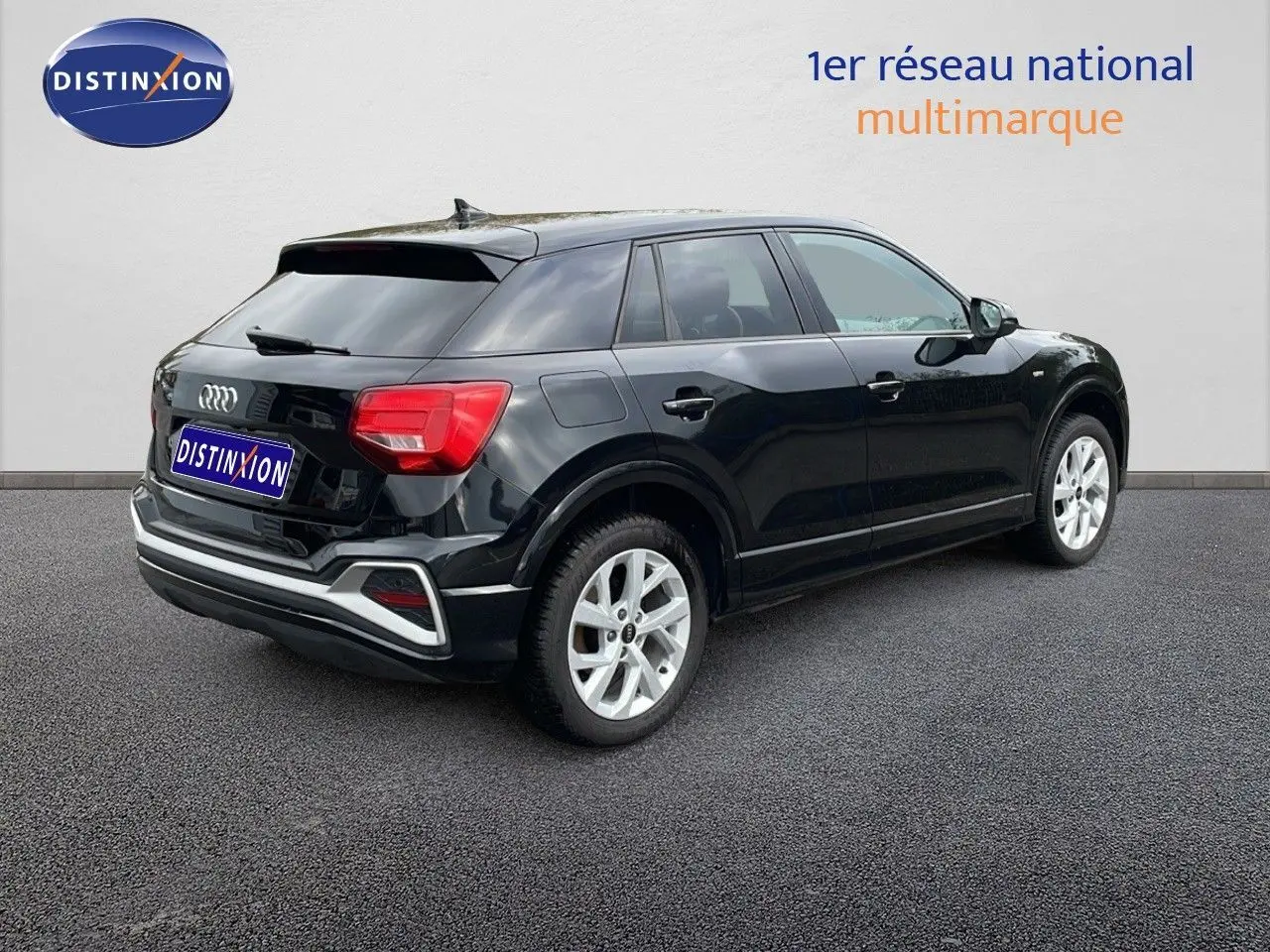 Audi Q2 noir mito metal vue 3/4 arrière côté droit, avec jantes argentées et feux arrière rouges visibles