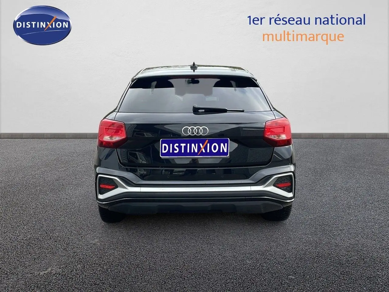 Vue arrière d'un Audi Q2 35 TFSI noir mito metal avec feux arrière rouges et logo quatre anneaux bien visible.